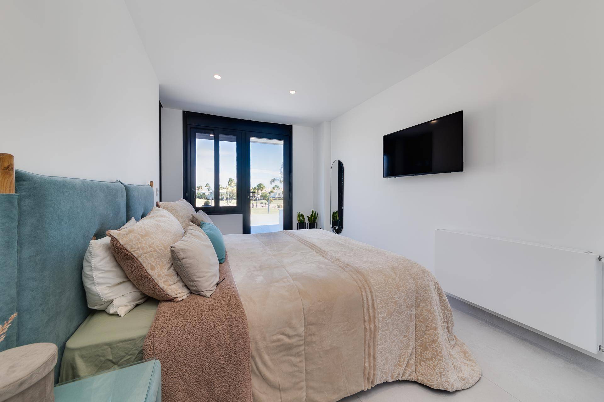 Geräumiges Schlafzimmer mit Doppelbett, Klimaanlage und Blick auf die Landschaft.