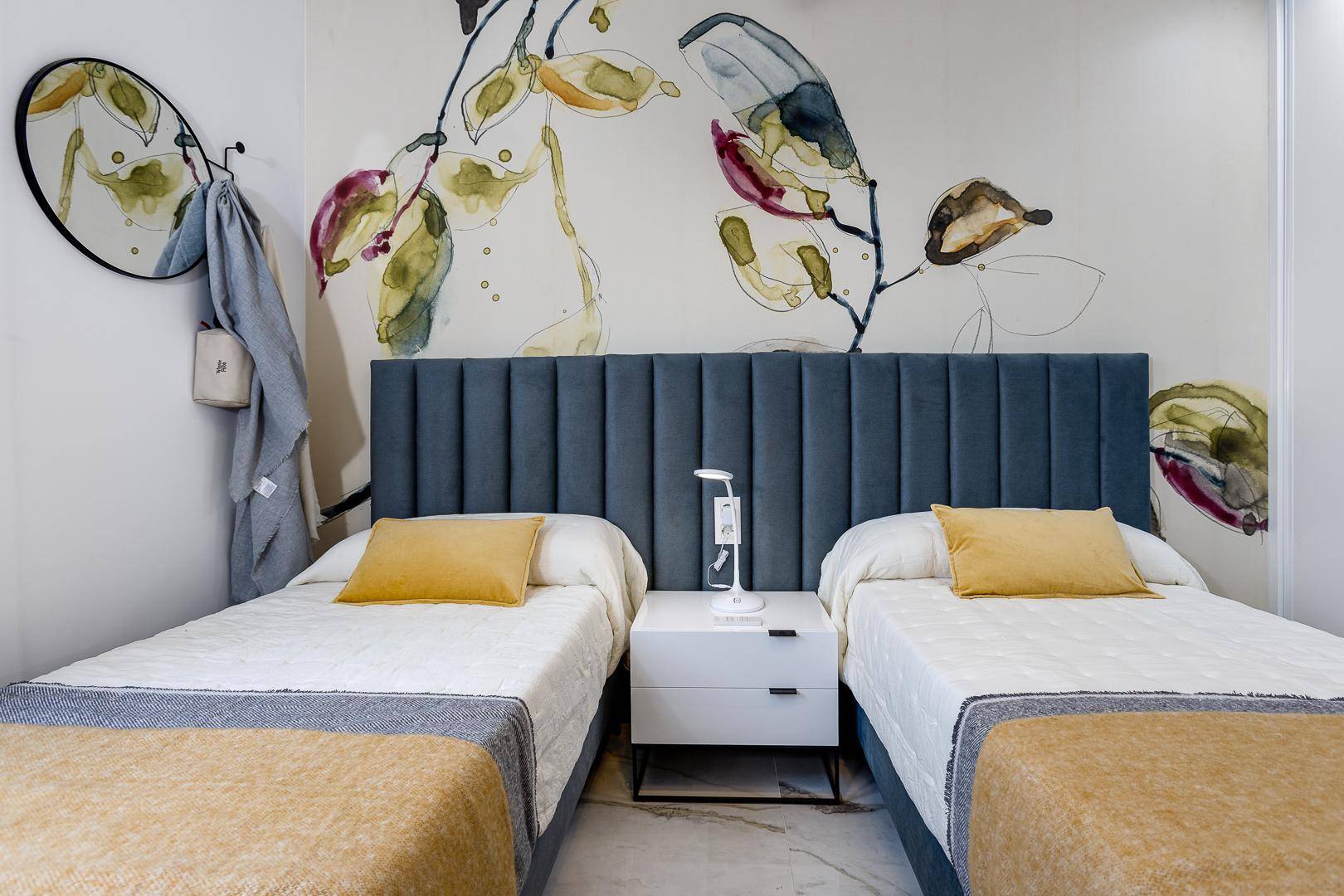 Gemütliches Schlafzimmer mit zwei Einzelbetten und dekorativer Wandgestaltung.
