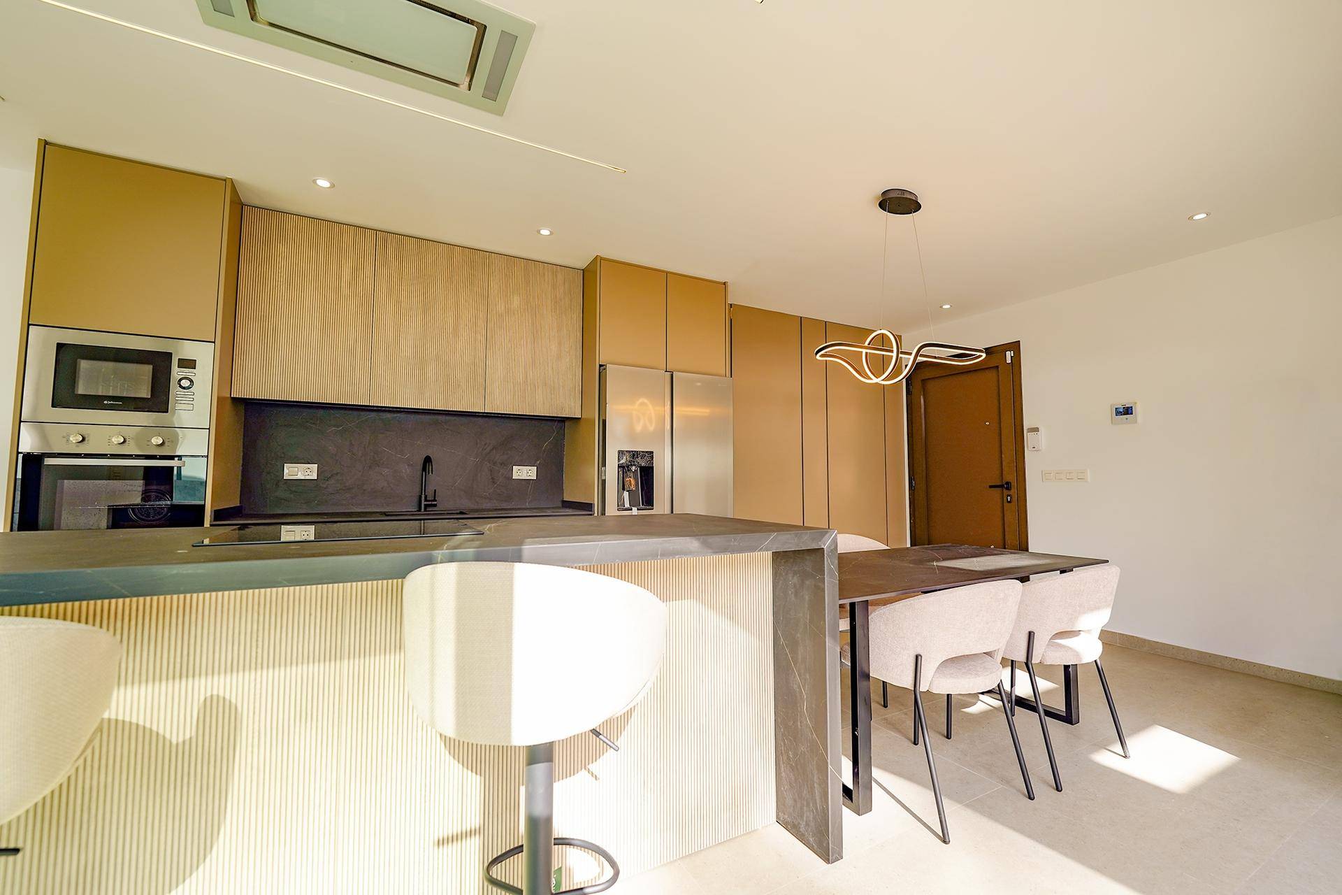 Moderne Küche mit Holzschränken, Kücheninsel und Essbereich, ideal für gesellige Mahlzeiten.