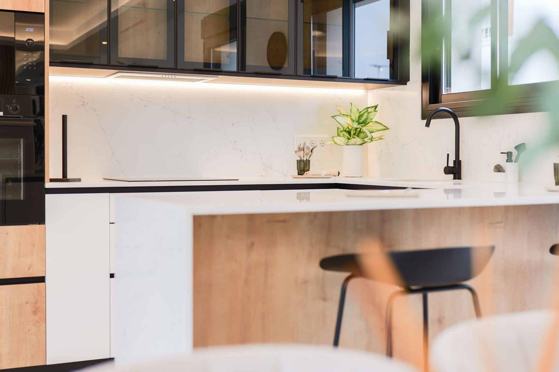 Moderne Küche mit integrierter Frühstücksbar und Hockern, offen zum Essbereich.