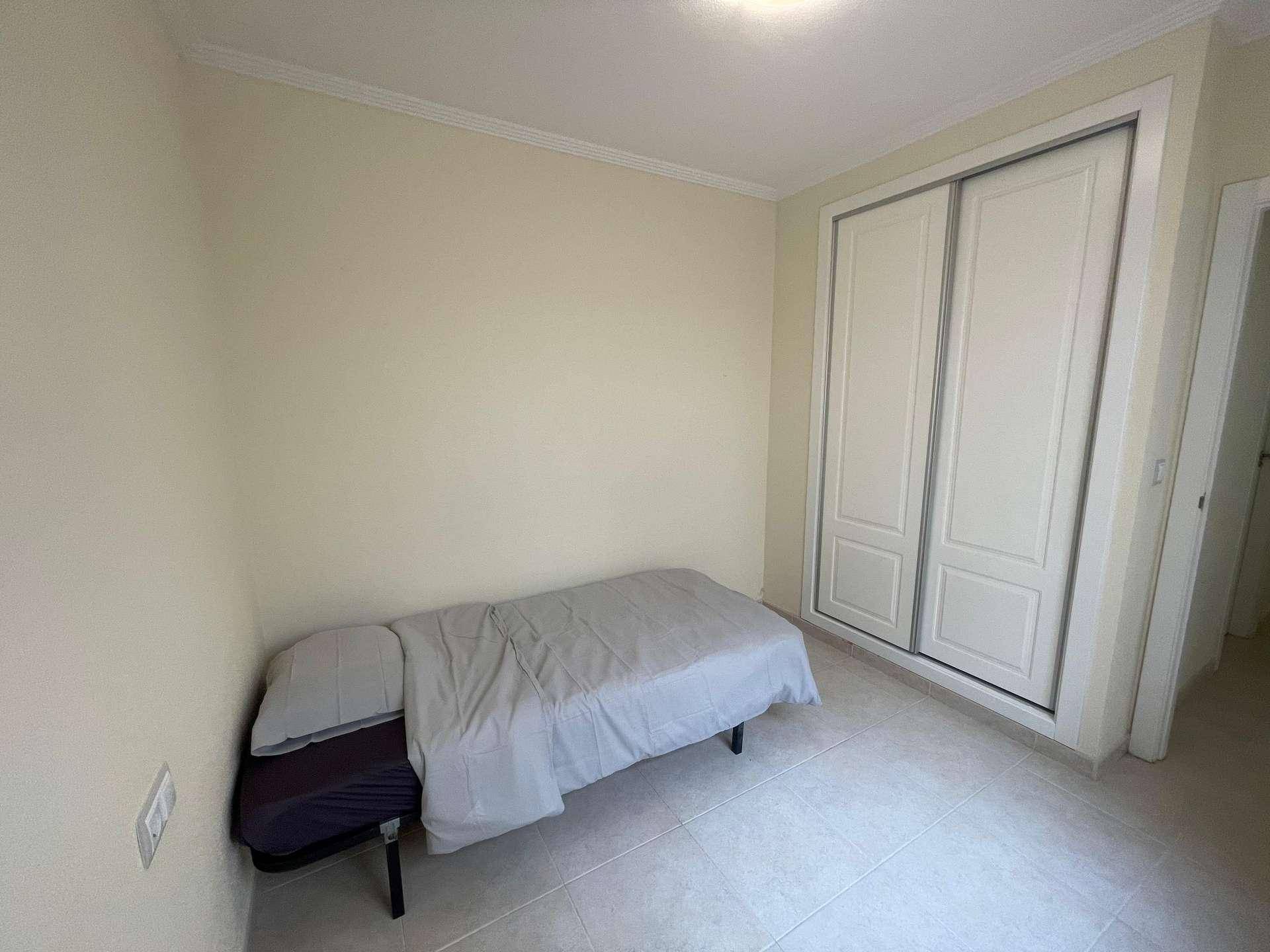 Helles Schlafzimmer mit Einzelbett und integriertem Einbauschrank, praktisch und platzsparend.