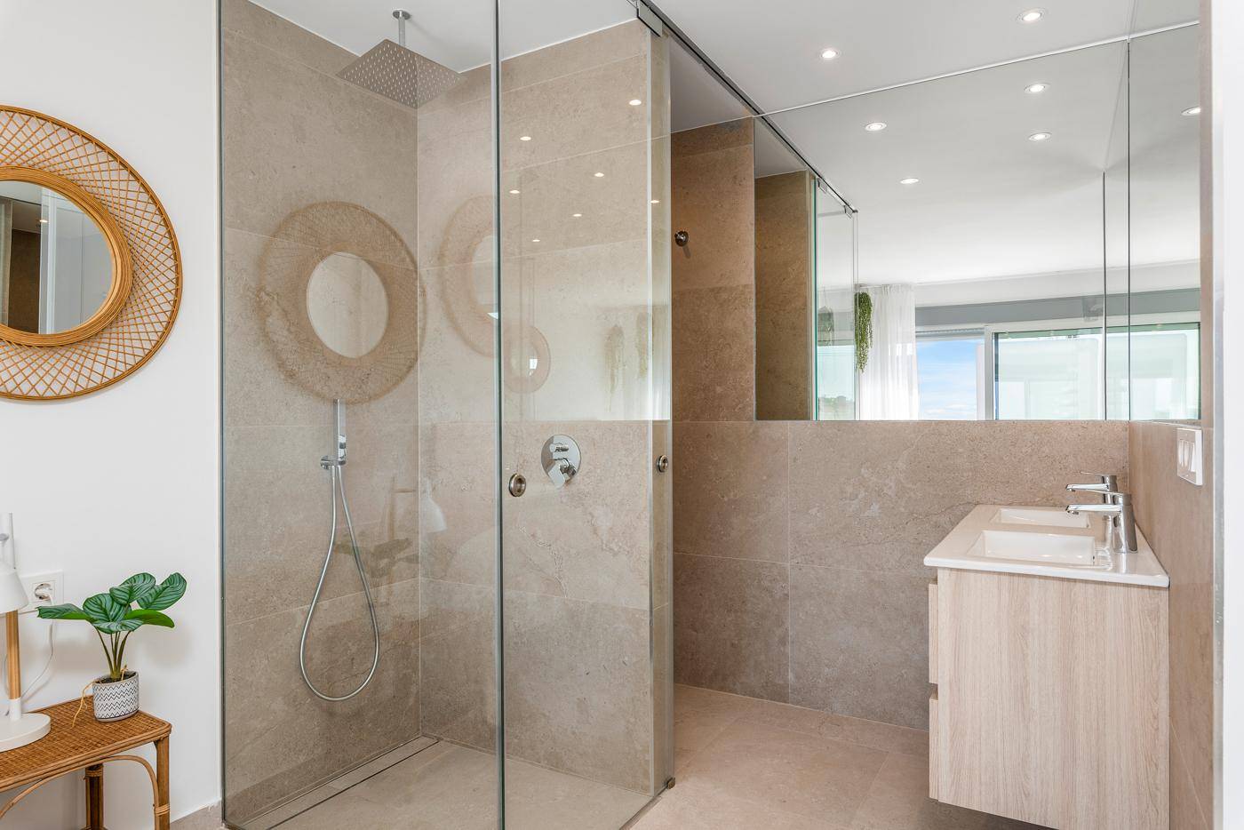 Modernes Badezimmer mit begehbarer Dusche, Doppelwaschbecken und großen Spiegeln.