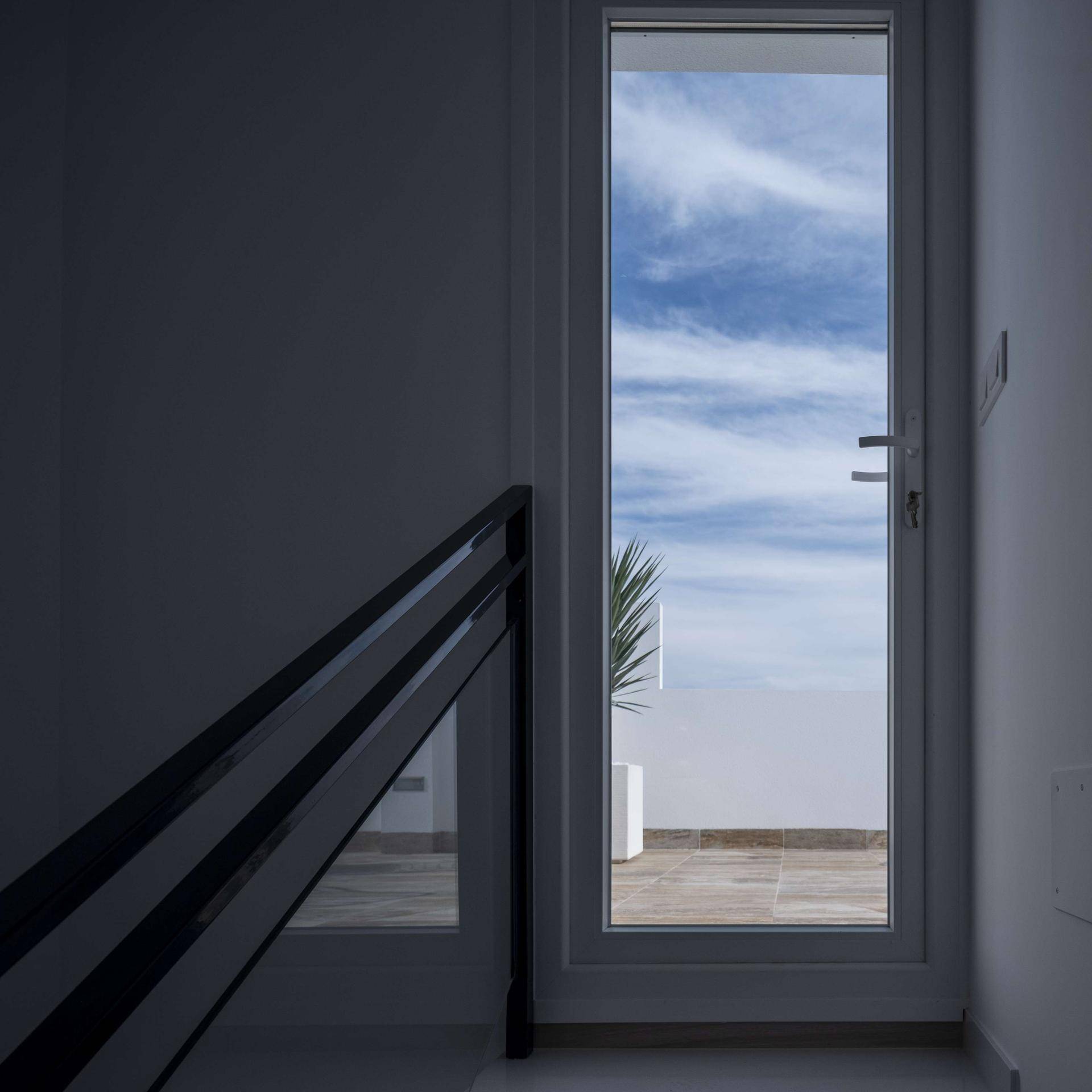 Heller Flur mit Zugang zur Dachterrasse und Blick auf den blauen Himmel.