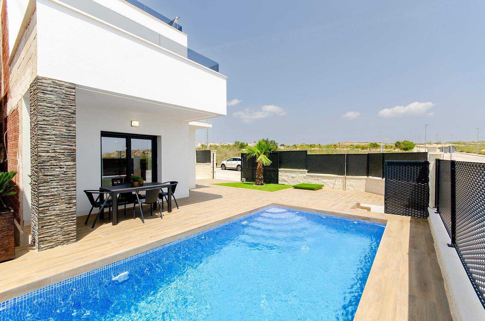 Sonniger Außenbereich mit Pool, Terrasse und moderner Architektur der Villa.
