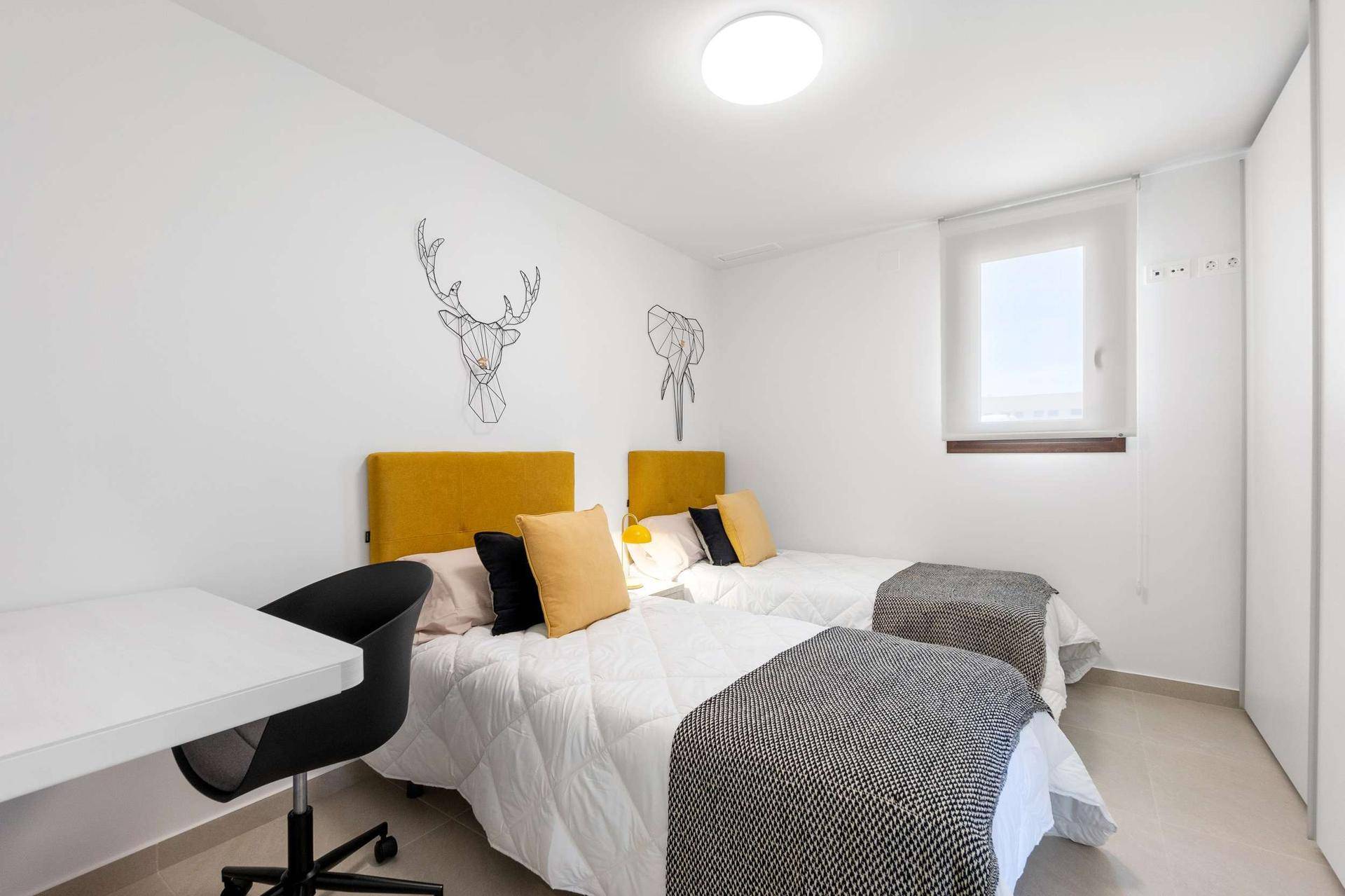Helles Schlafzimmer mit zwei Einzelbetten und modernem, minimalistischem Wanddekor.