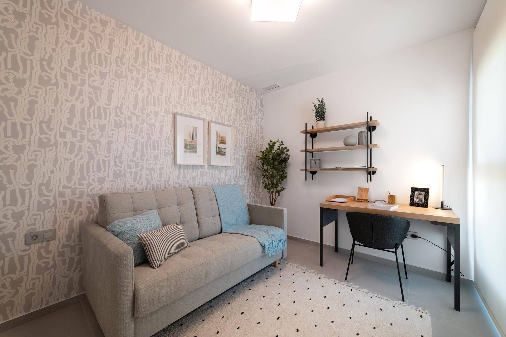 Funktionales Arbeitszimmer mit Schreibtisch, Regal und einem Schlafsofa für Gäste.