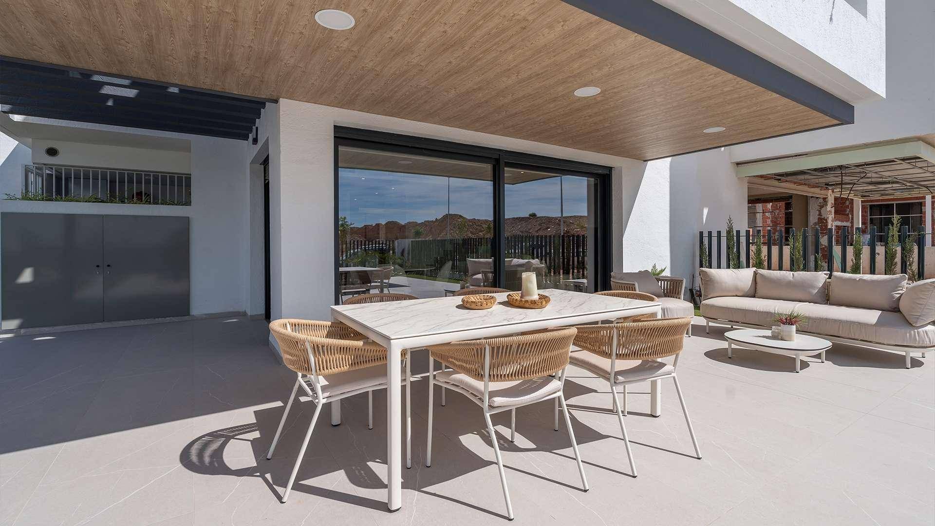 Geräumige überdachte Terrasse mit modernem Esstisch und bequemen Lounge-Möbeln für entspannte Stunden.