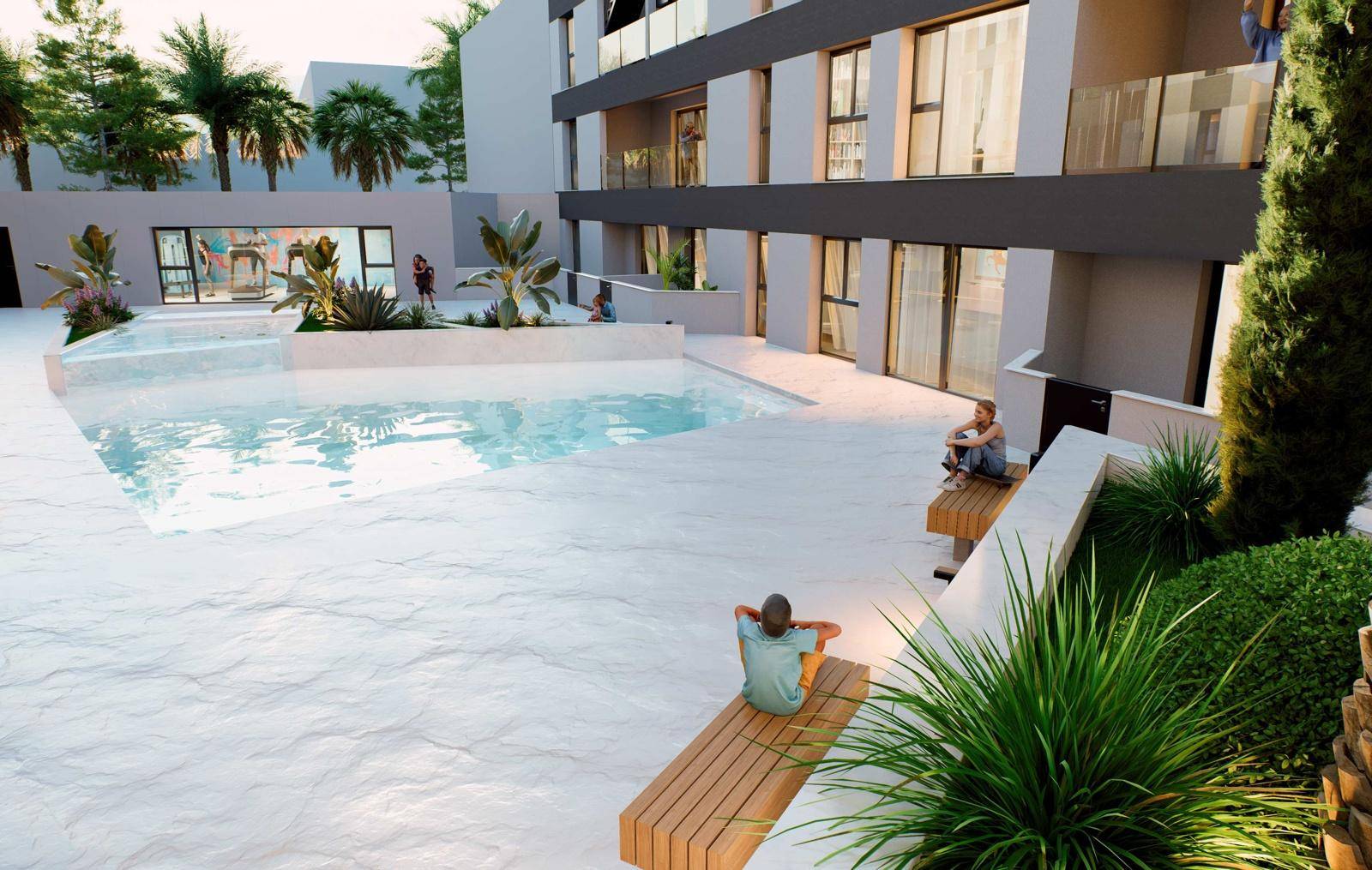 Sitzbereich am Pool im Innenhof mit Holzbänken und üppiger Bepflanzung.