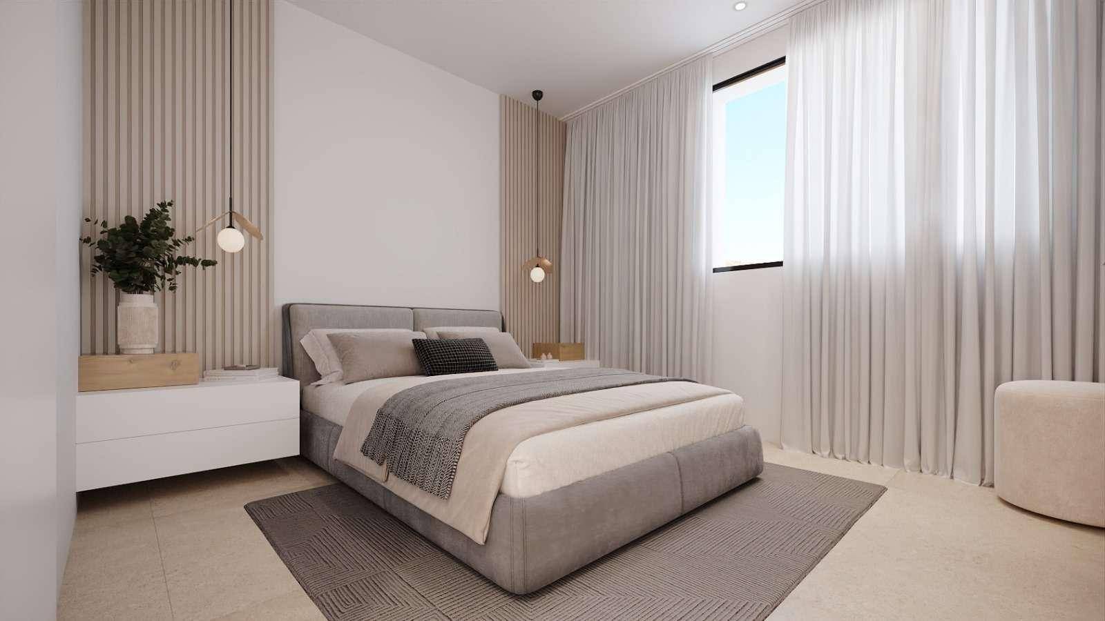 Helles Schlafzimmer mit modernem Bett, Nachttischen und einem großen Fenster mit weißen Vorhängen.