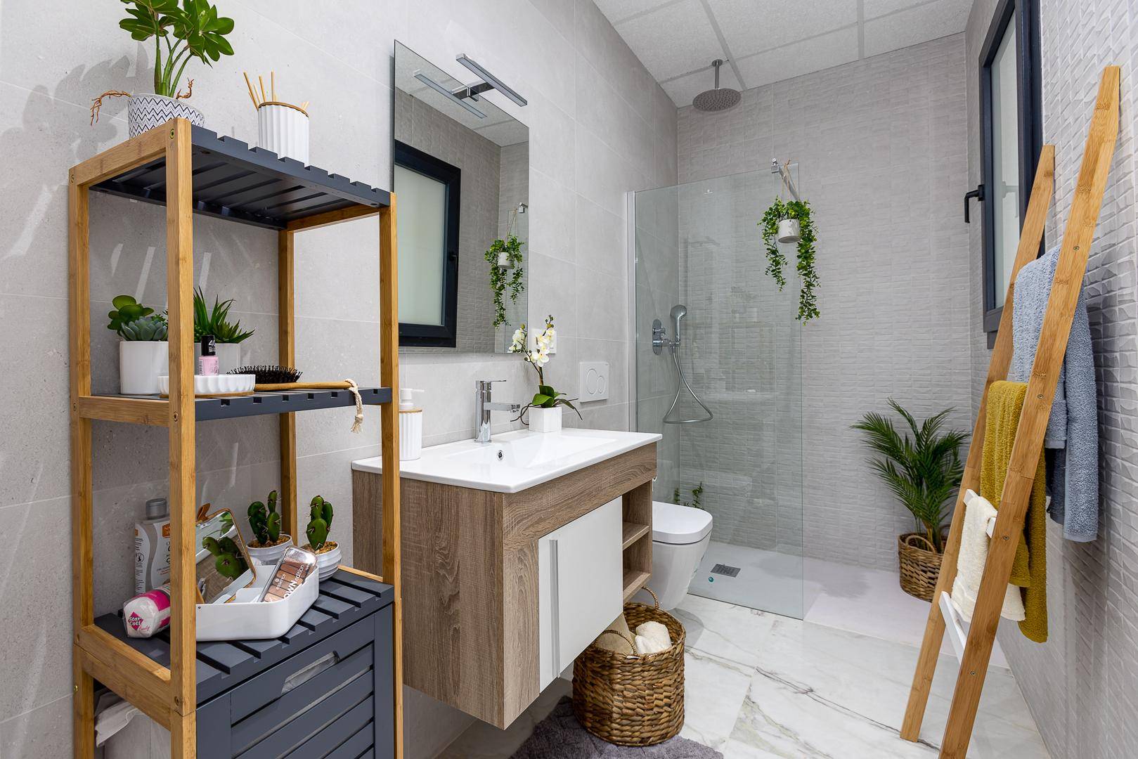 Modernes Badezimmer mit begehbarer Dusche, schwebendem Waschtisch und dekorativen Pflanzen.