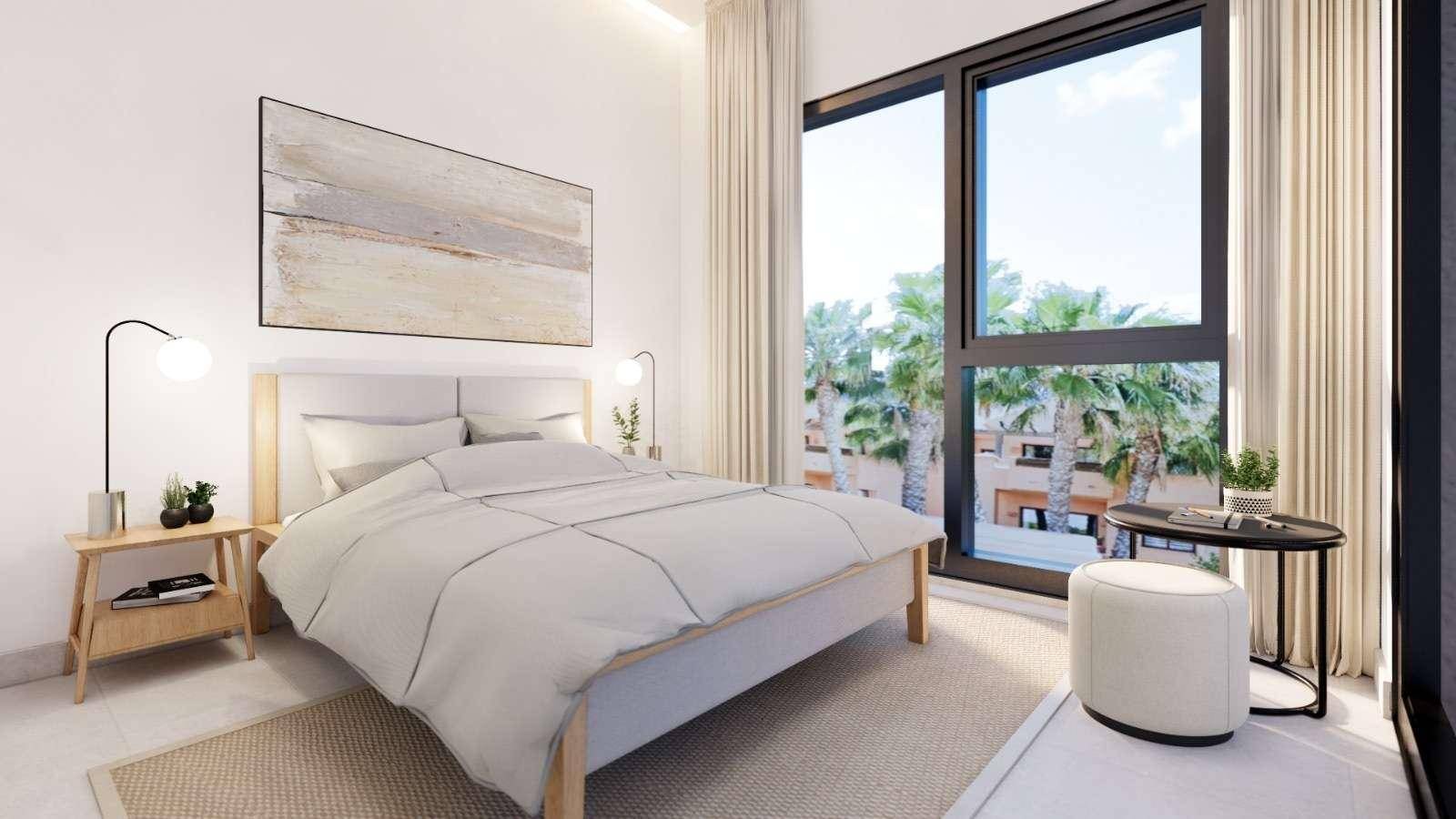 Modernes Schlafzimmer mit großem Fenster, das einen Blick auf Palmen und viel Tageslicht bietet.