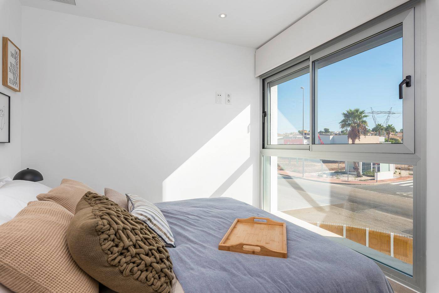 Helles Schlafzimmer mit großem Fenster und Blick auf die Umgebung.