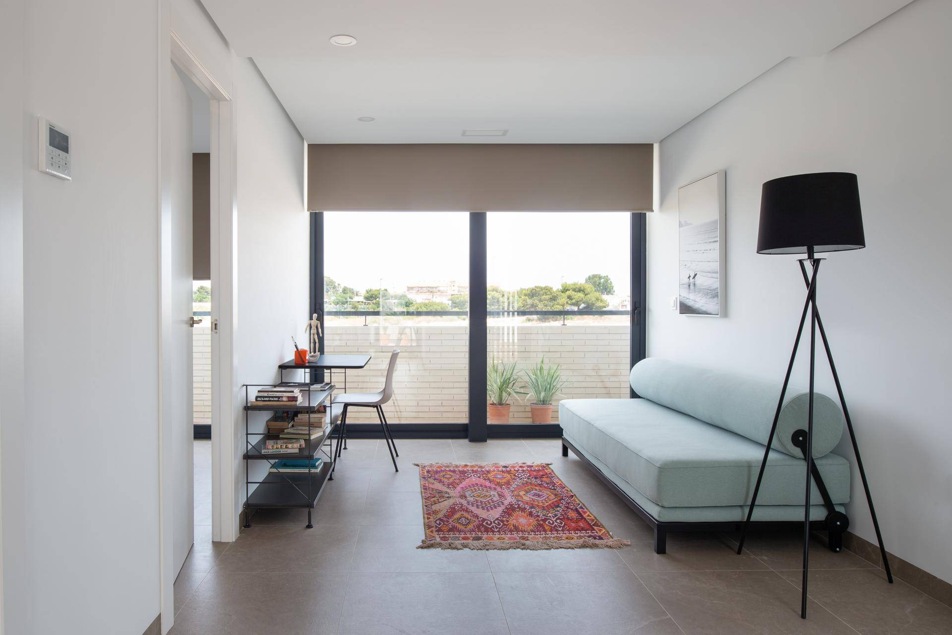 Helles Zimmer mit Tagesbett, kleinem Schreibtisch und großem Fenster mit Blick ins Grüne.