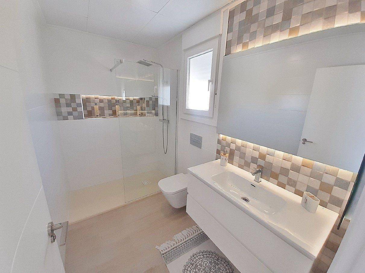 Modernes Badezimmer mit ebenerdiger Dusche, schwebendem Waschtisch und Fenster.