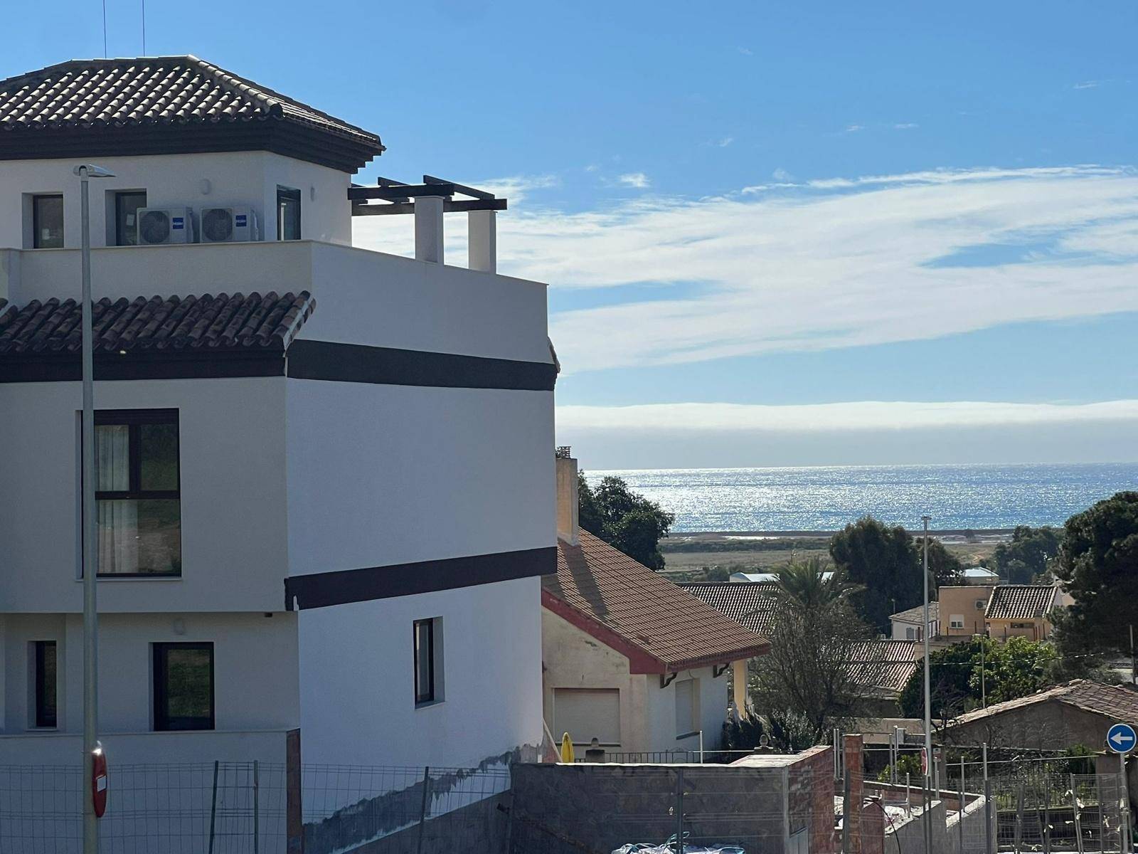 Moderne Gebäudefassade mit Blick auf das glitzernde Meer und die Küstenlandschaft.