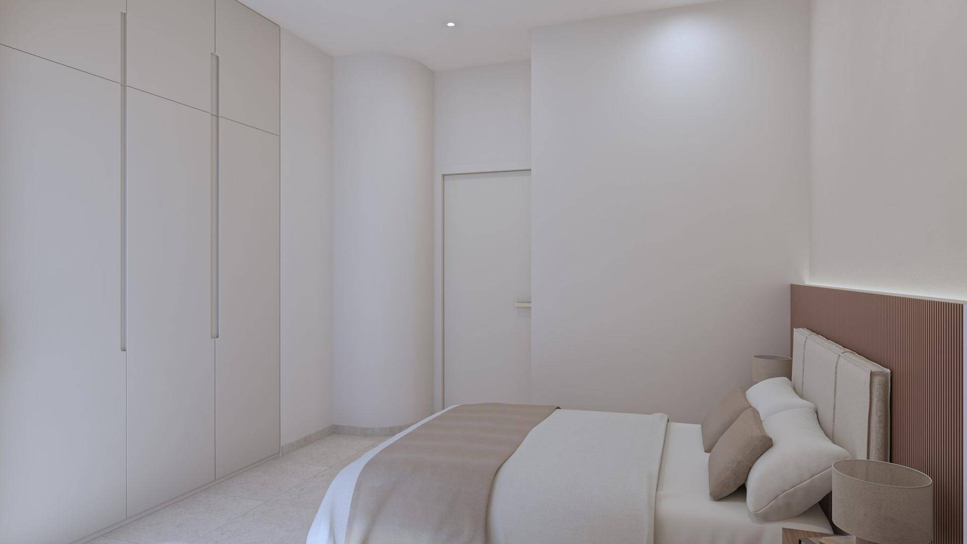 Geräumiges Schlafzimmer mit Doppelbett und einem großen, wandintegrierten Kleiderschrank.