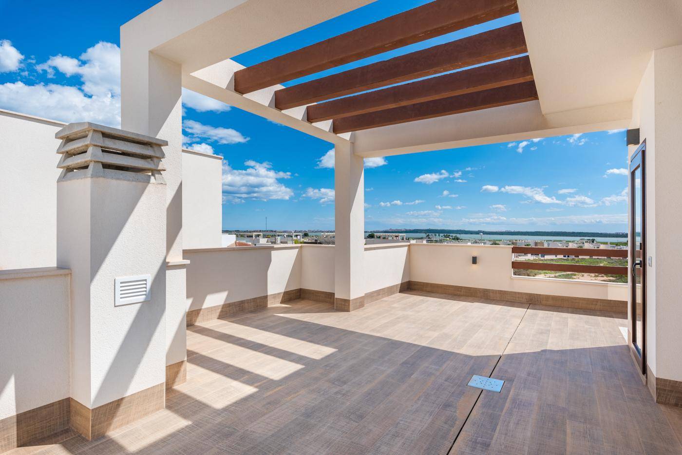 Sonnige Dachterrasse mit Pergola und weitem Blick, bietet viel Platz für Entspannung.