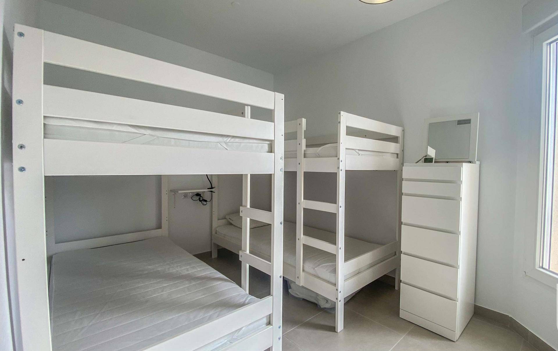 Kinderzimmer mit zwei Etagenbetten und Kommode, ideal für Gäste.