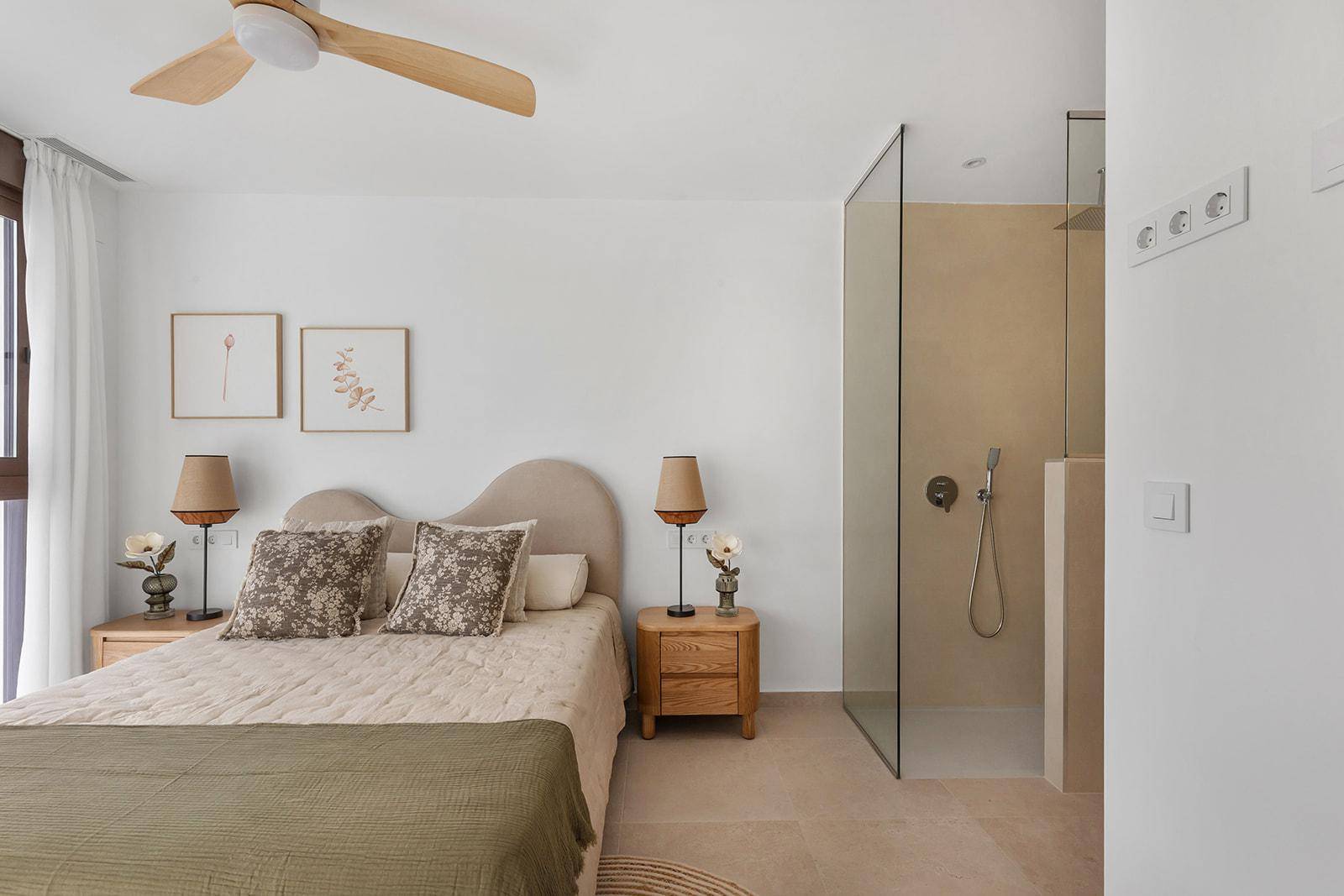 Helles Schlafzimmer mit Deckenventilator und integriertem Duschbereich, modern eingerichtet.