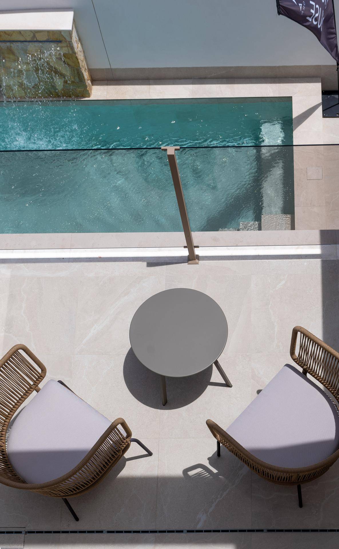 Gemütlicher Außenbereich mit Sitzgelegenheiten und Blick auf den privaten Pool mit Wasserfall.