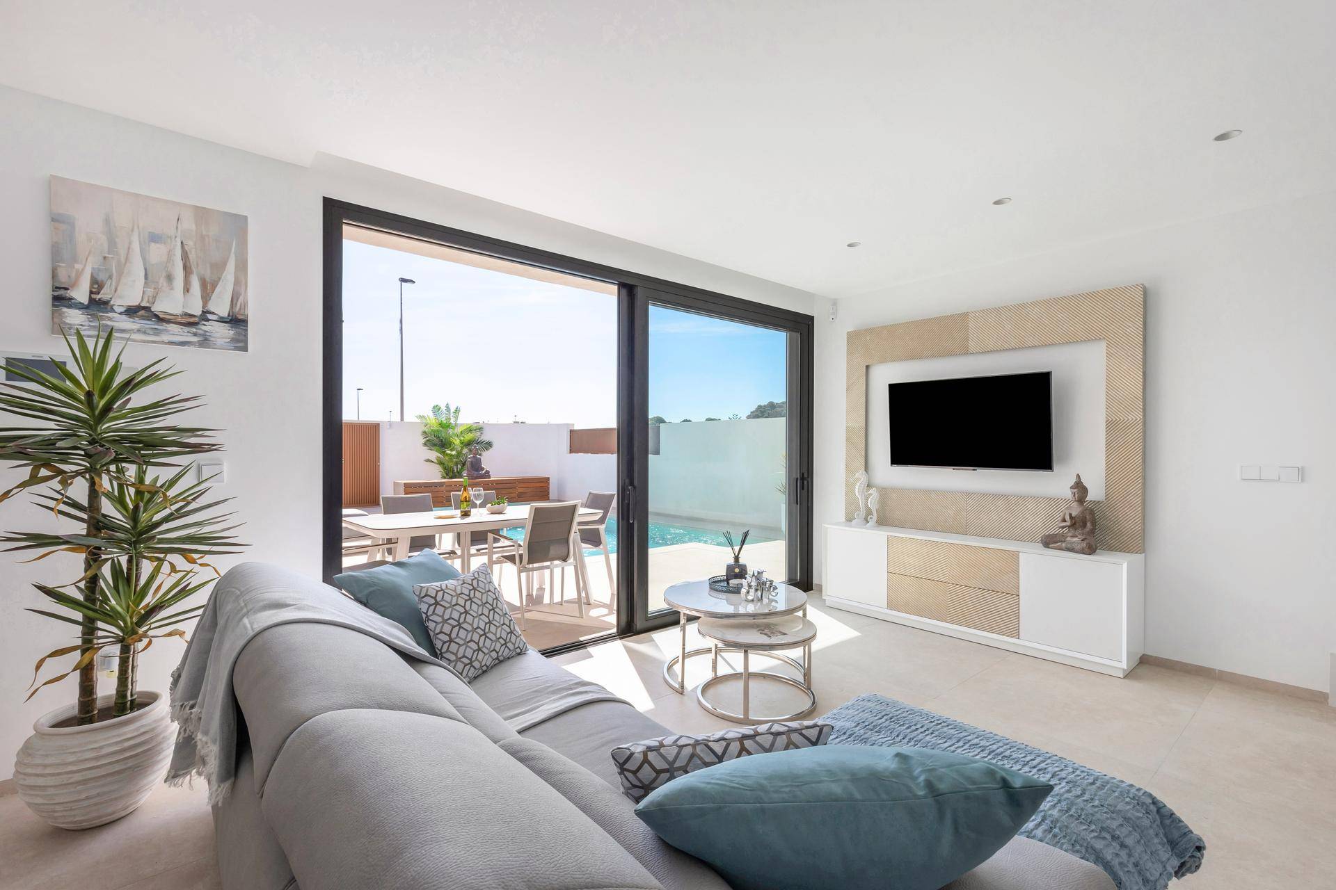 Lichtdurchflutetes Wohnzimmer mit bequemer Couch und direktem Zugang zur Terrasse und zum Pool.