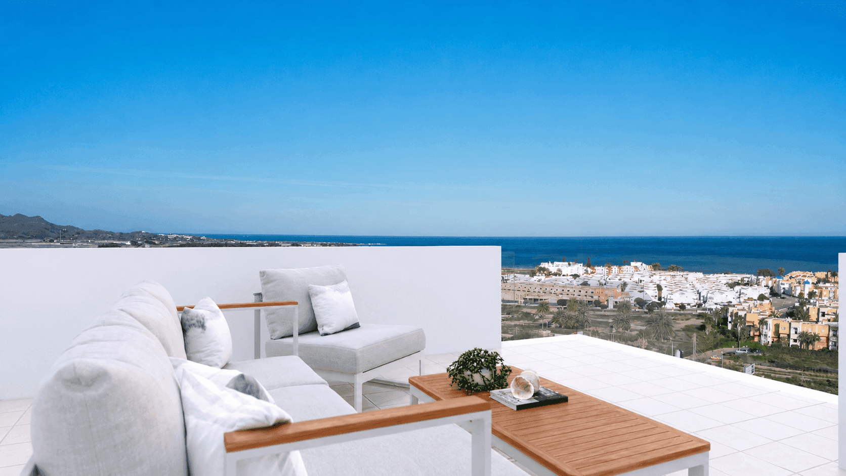 Moderne Dachterrasse mit bequemen Loungemöbeln und weitem Blick über das Meer und die Stadt.