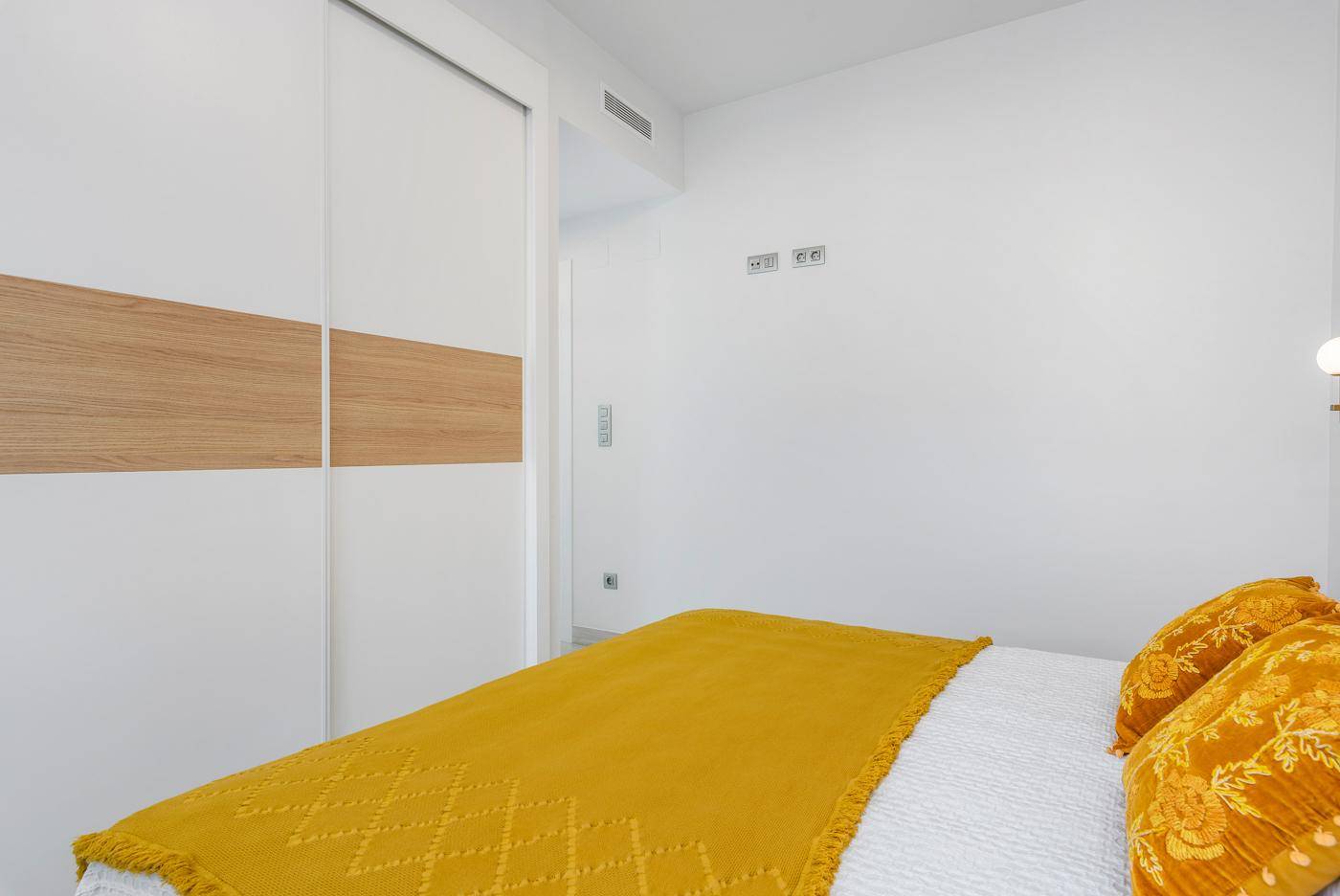 Schlafzimmer mit integriertem Schrank und modernem Design, hell und funktional eingerichtet.