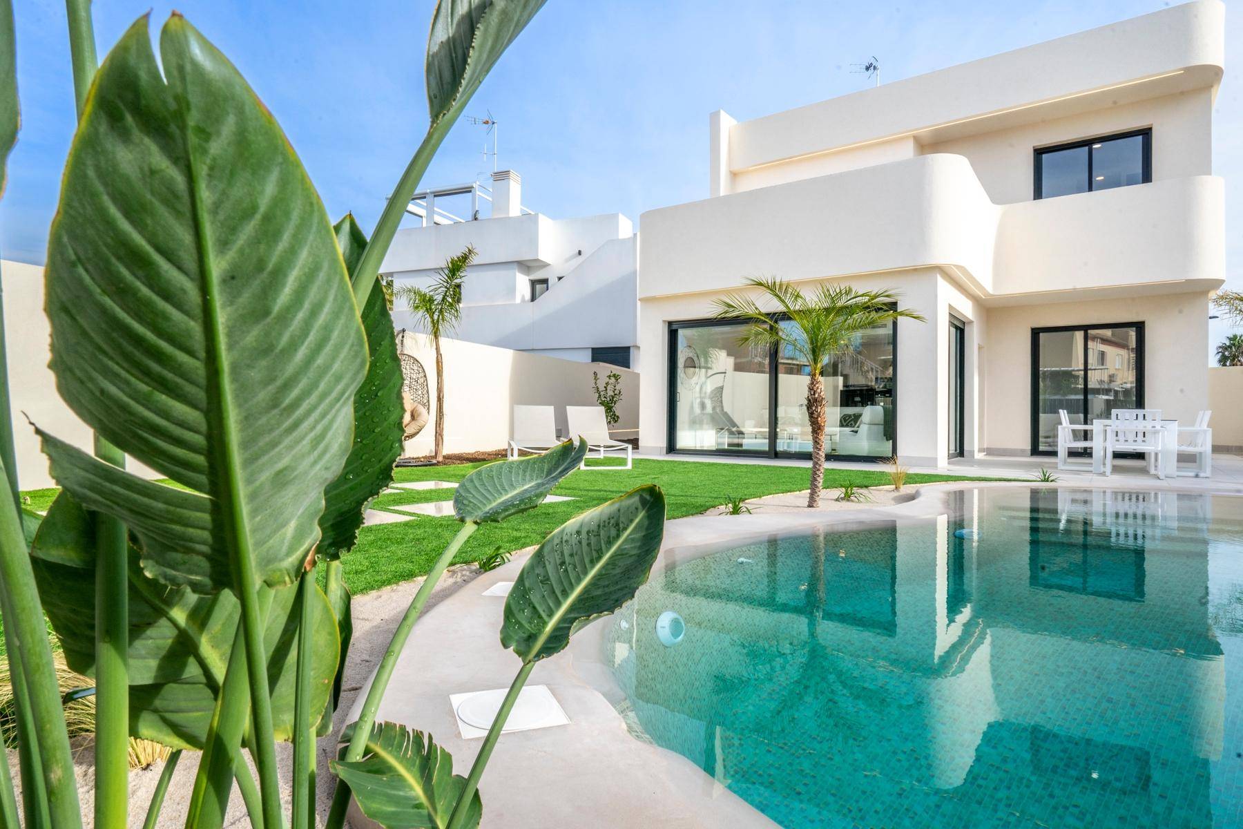 Moderne Villa mit privatem Pool und gepflegtem Garten, umgeben von tropischen Pflanzen.
