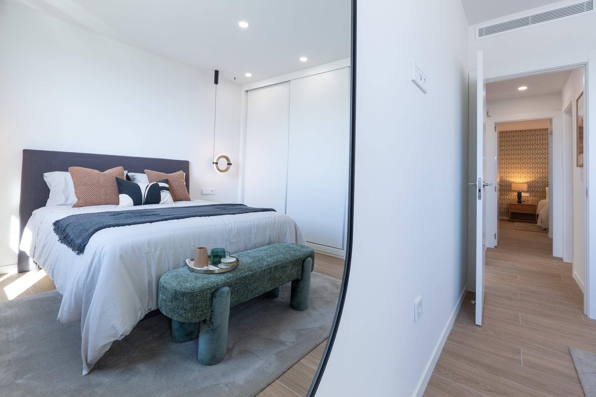Modernes Schlafzimmer mit Einbauschrank und Blick in den angrenzenden Flur.