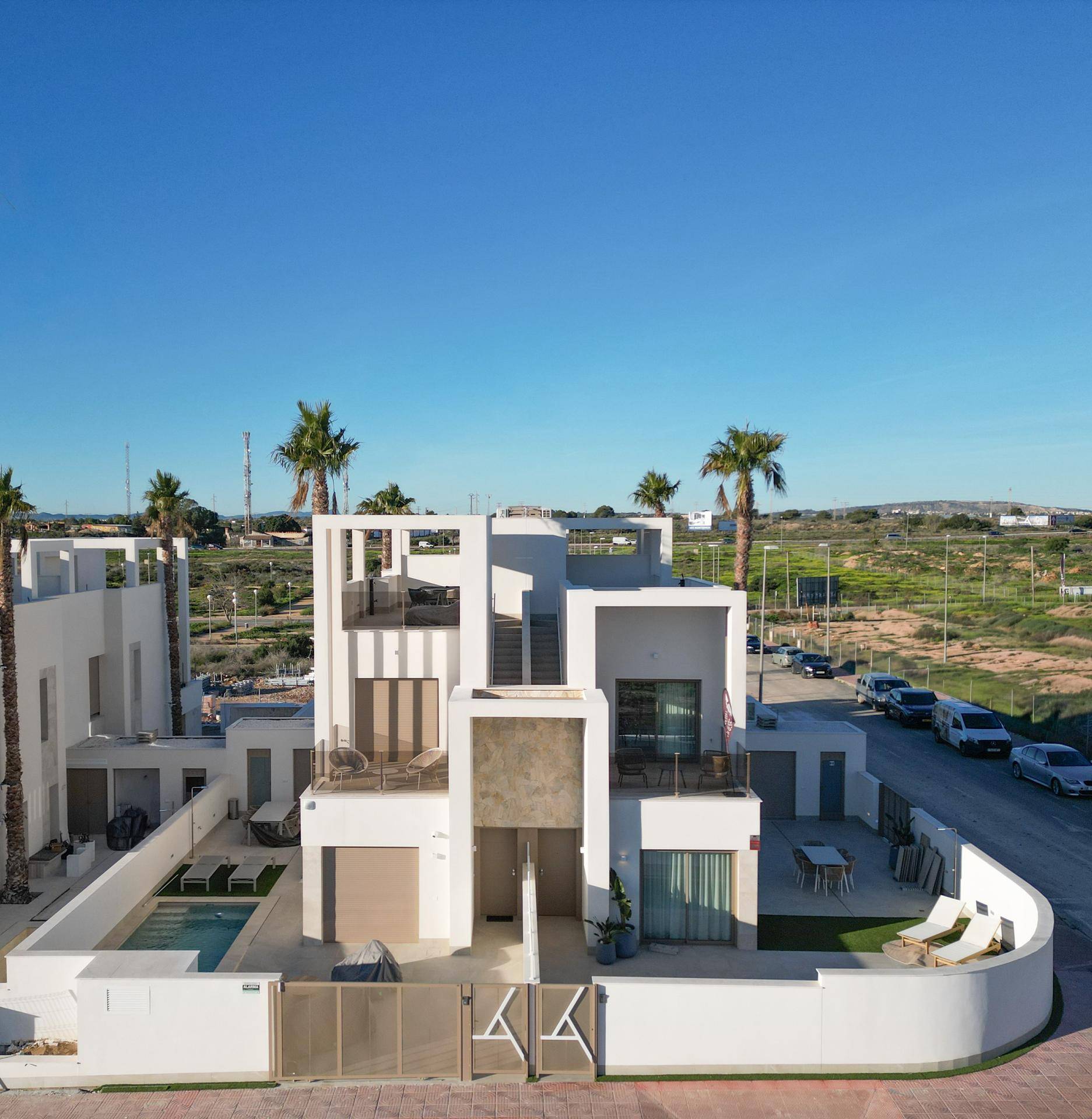 Luftaufnahme einer modernen Villa mit privatem Pool und Gartenbereich in einer neuen Wohnsiedlung.