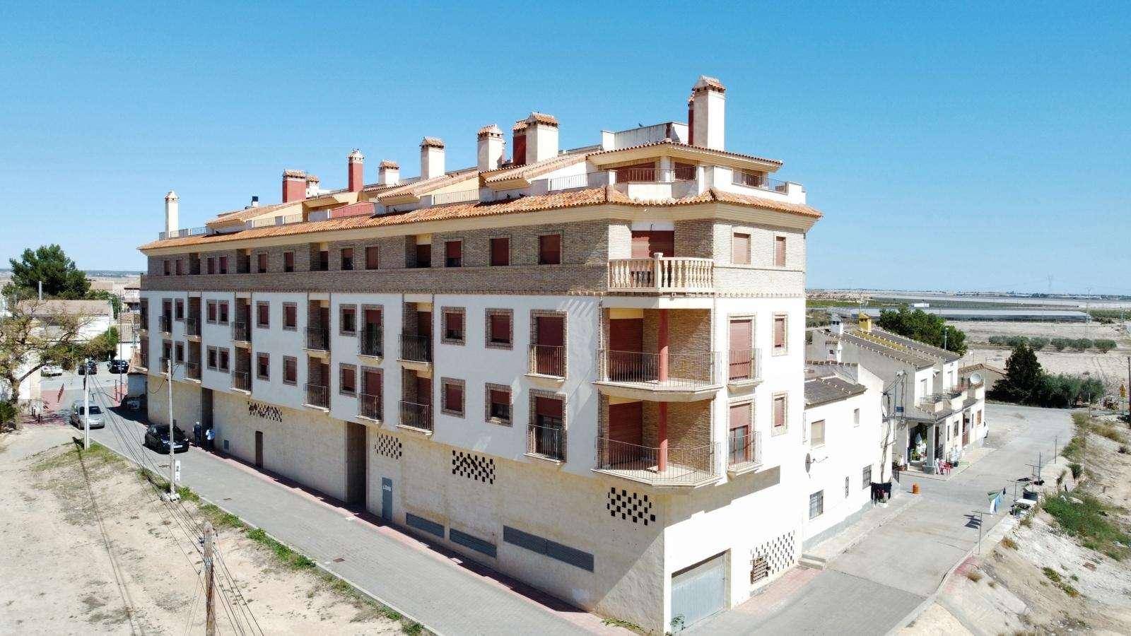 Luftaufnahme eines Wohnkomplexes mit Ziegeldächern und Balkonen, umgeben von einer ländlichen Umgebung.