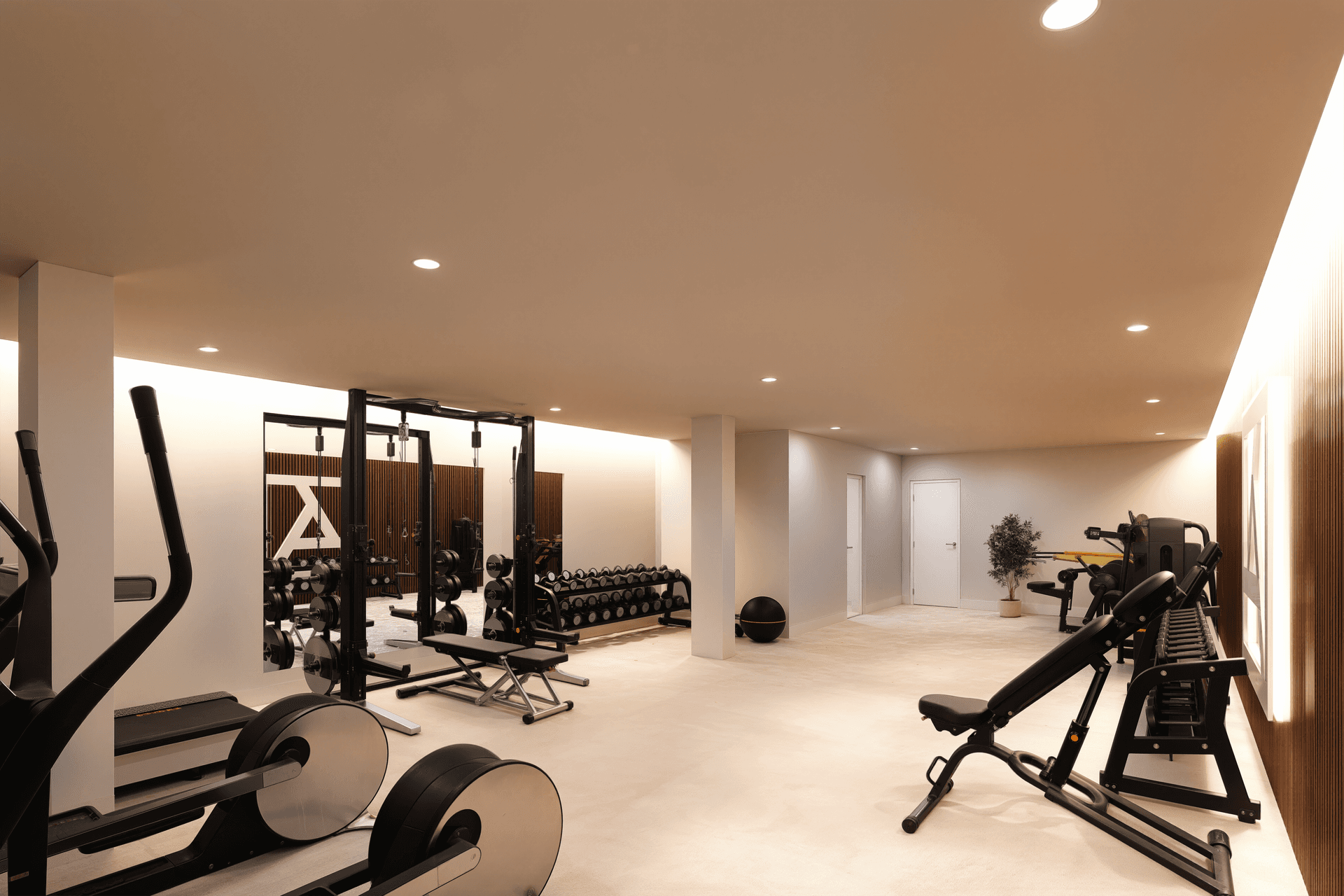 Gut ausgestatteter Fitnessraum mit modernen Trainingsgeräten und viel Platz für Sport.