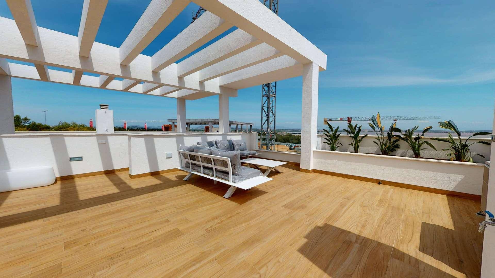 Moderne Dachterrasse mit Holzfußboden, Pergola, bequemen Sitzmöbeln und Pflanzen.