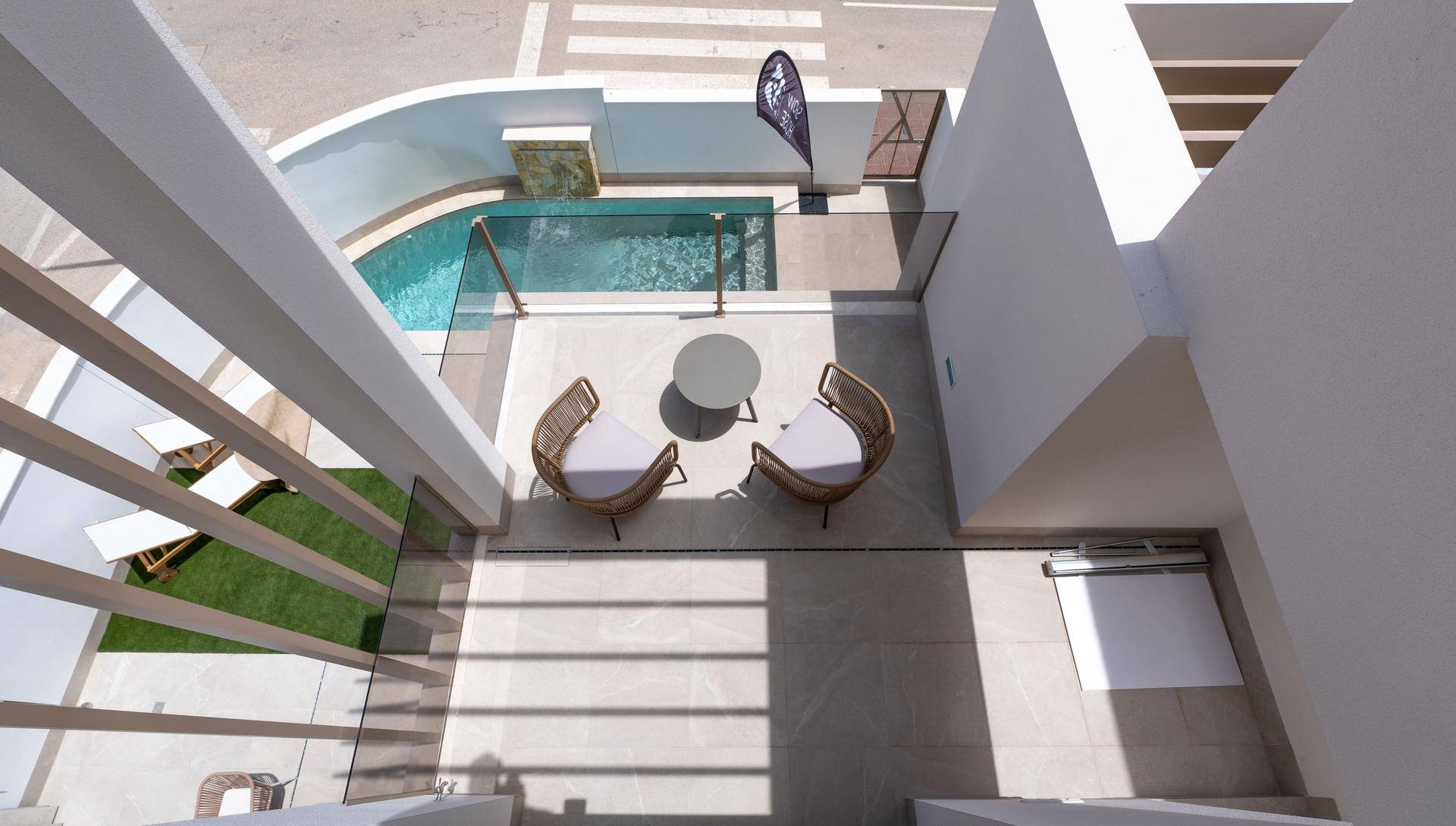 Terrasse mit modernen Outdoor-Möbeln und Blick auf den privaten Pool und die umliegende Bebauung.