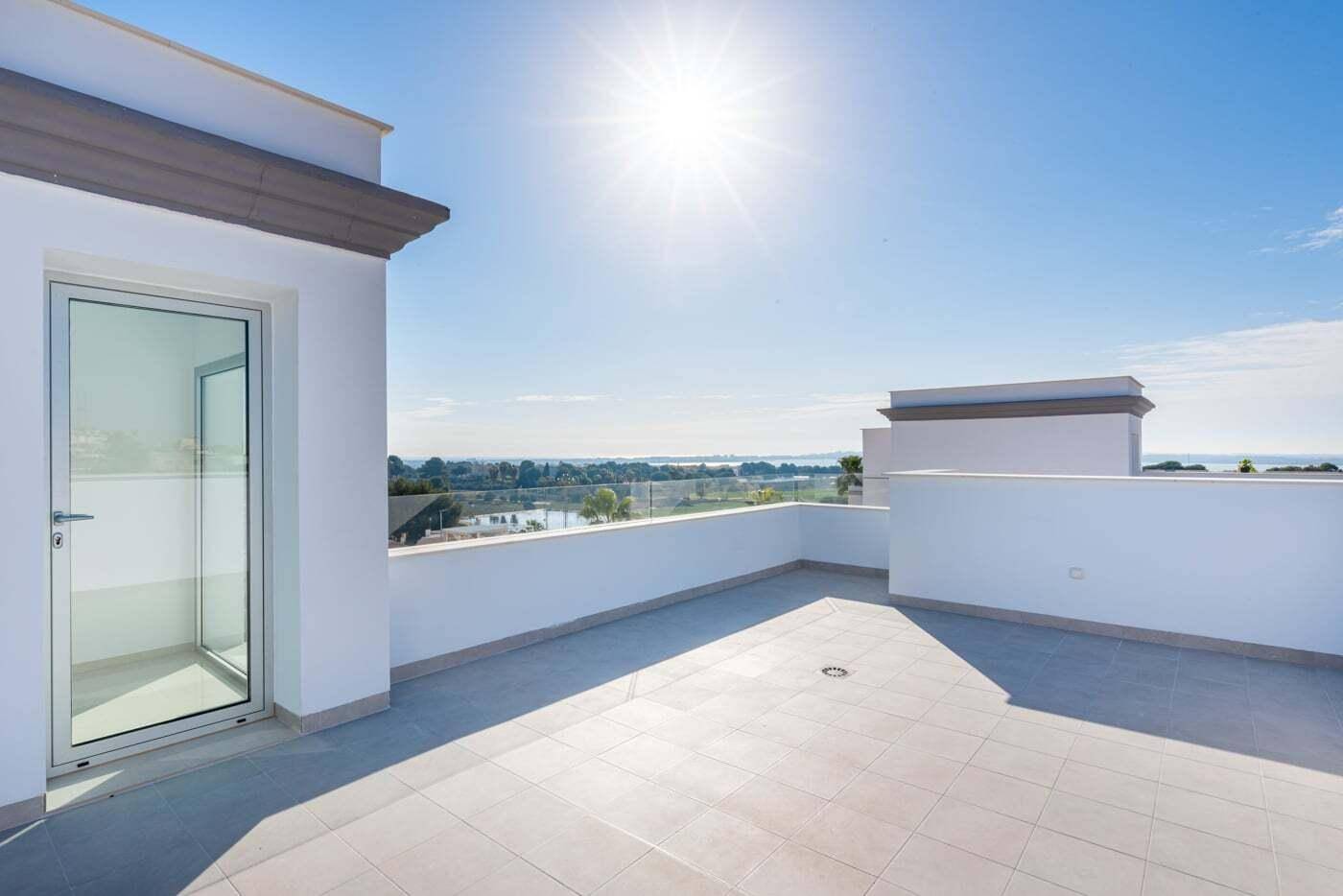 Sonnige Dachterrasse mit Zugang zum Innenbereich und weitem Blick in die Ferne.