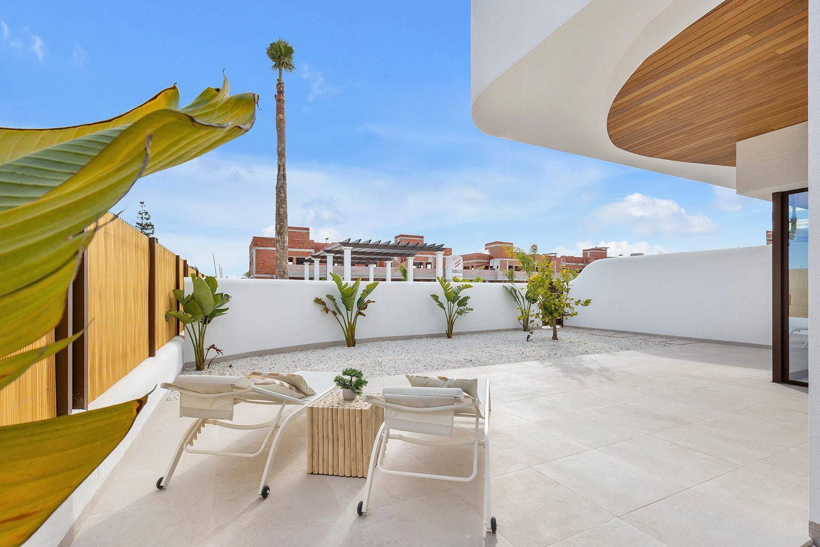 Terrasse mit Sonnenliegen und Blick auf die umliegende Wohnbebauung.