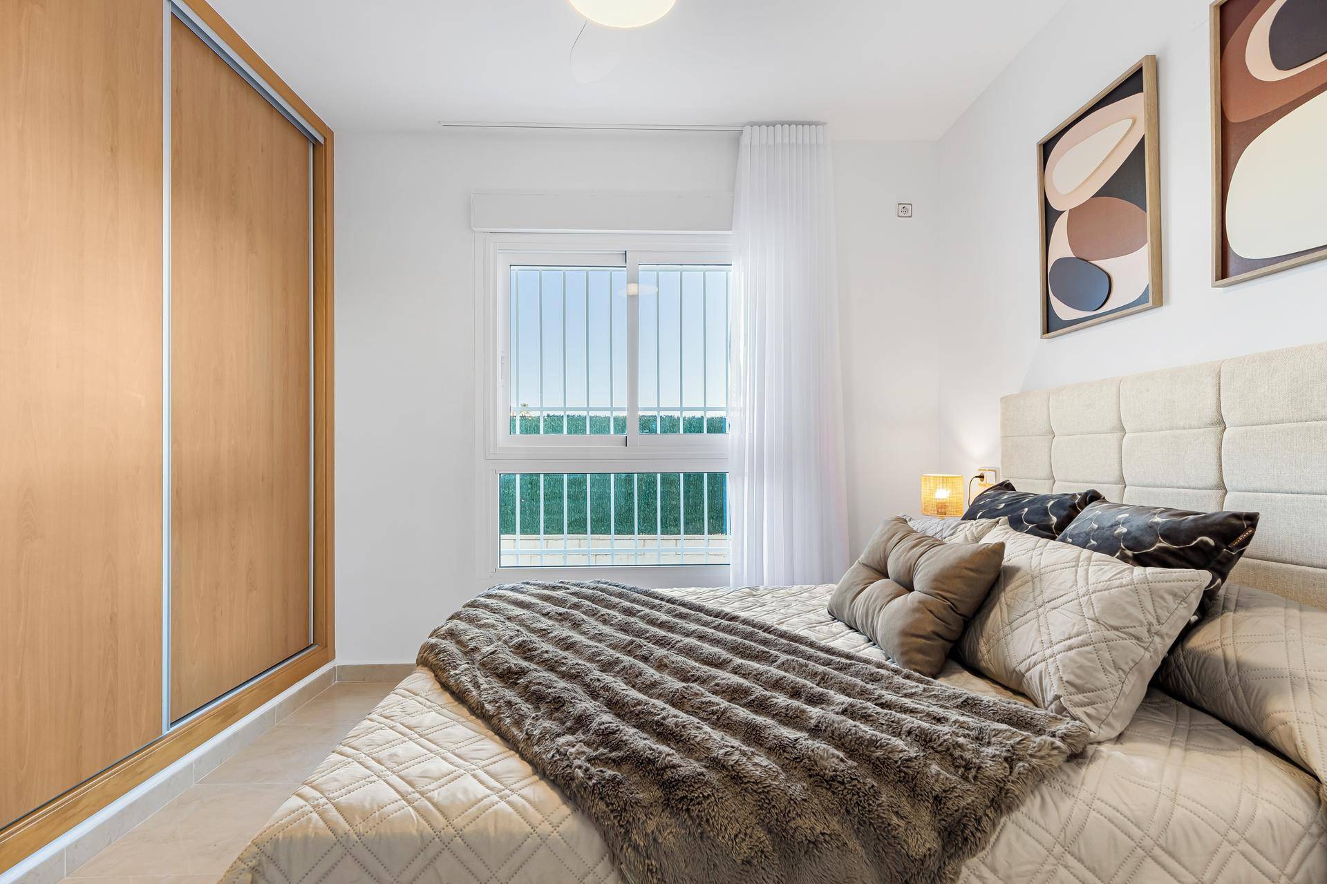 Gemütliches Schlafzimmer mit großem Bett, Einbauschrank und Fenster mit Blick ins Grüne.