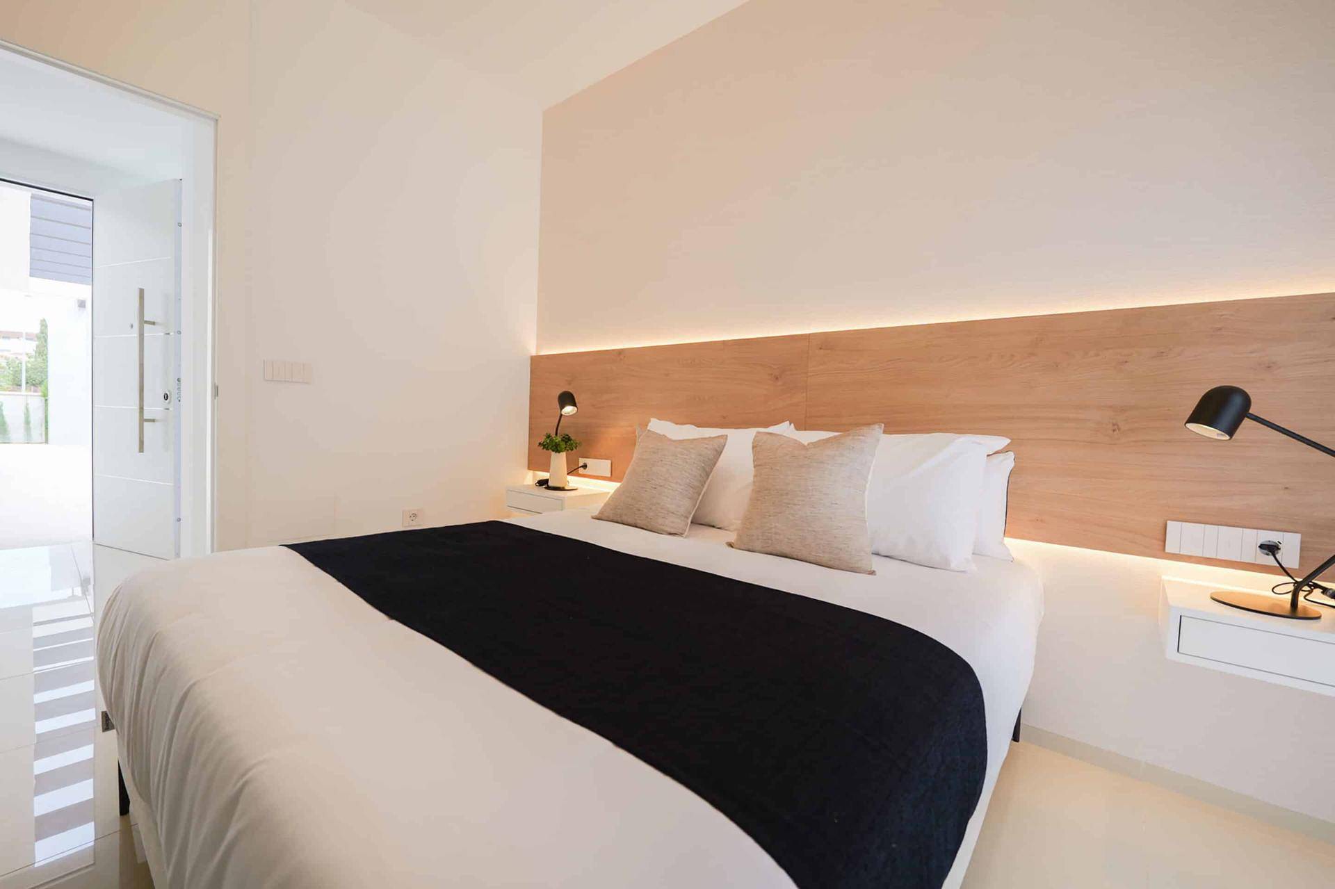 Schlafzimmer mit minimalistischem Design, Holzakzenten und Zugang zum Flur.