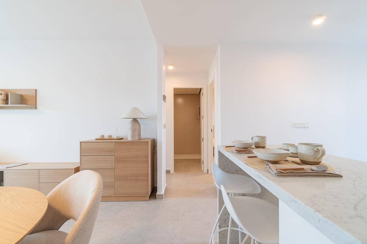 Blick vom Essbereich in den Flur, mit offener Küche und modernem Interieur.