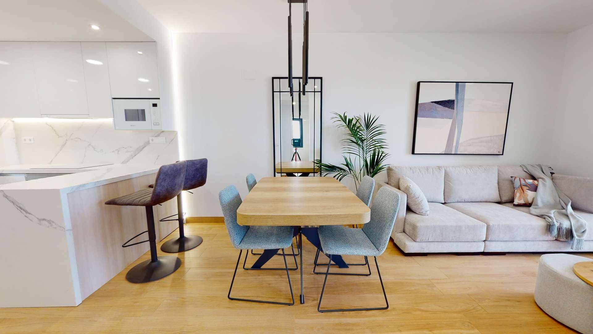 Offener Wohn-Essbereich mit moderner Küche, Esstisch und gemütlichem Sofa.