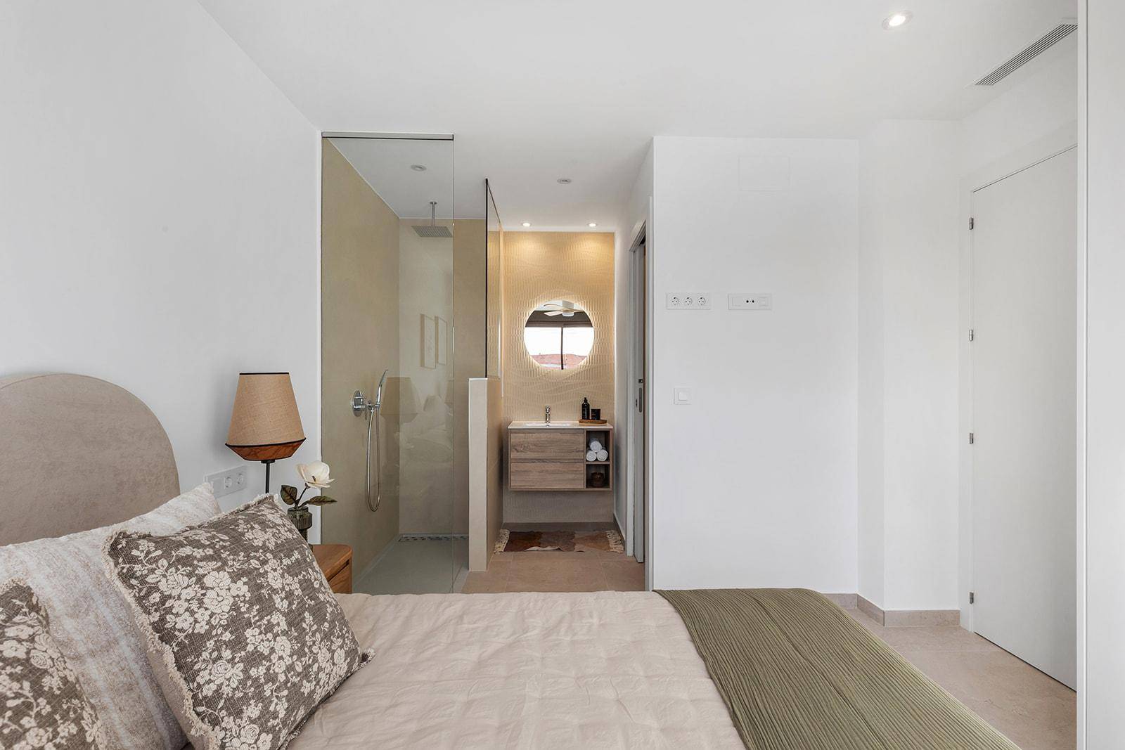 Schlafzimmer mit direktem Zugang zu einem modernen Duschbad und Deckenventilator.