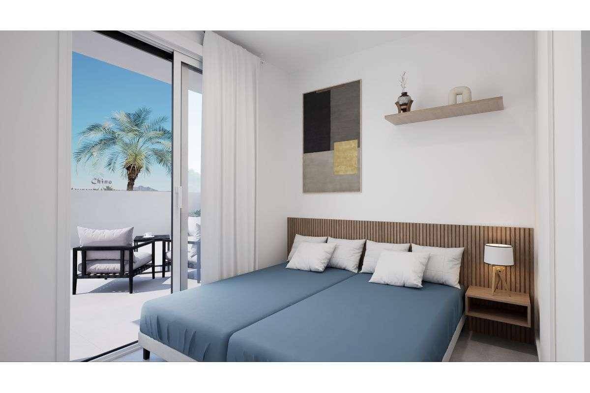 Modernes Schlafzimmer mit Doppelbett, Holzkopfteil und direktem Zugang zum Balkon.