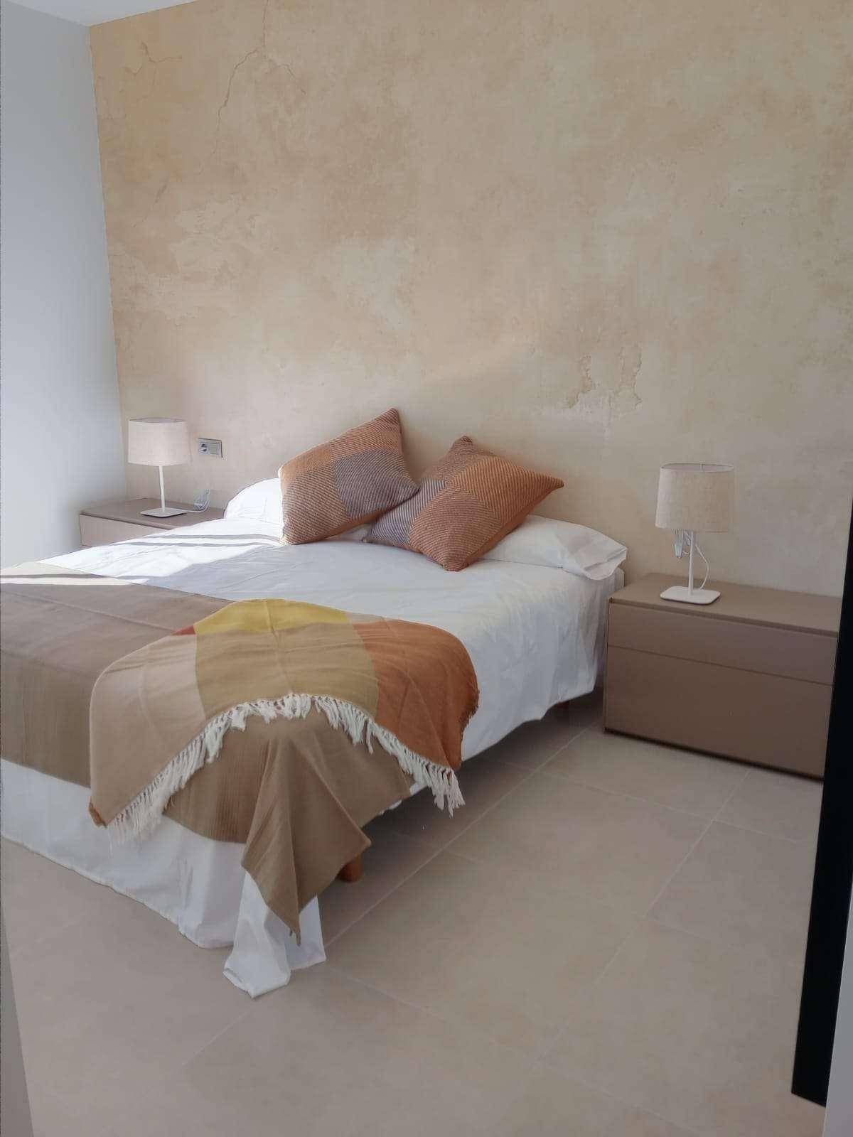 Schlafzimmer mit beiger Akzentwand und modernen Nachttischen.