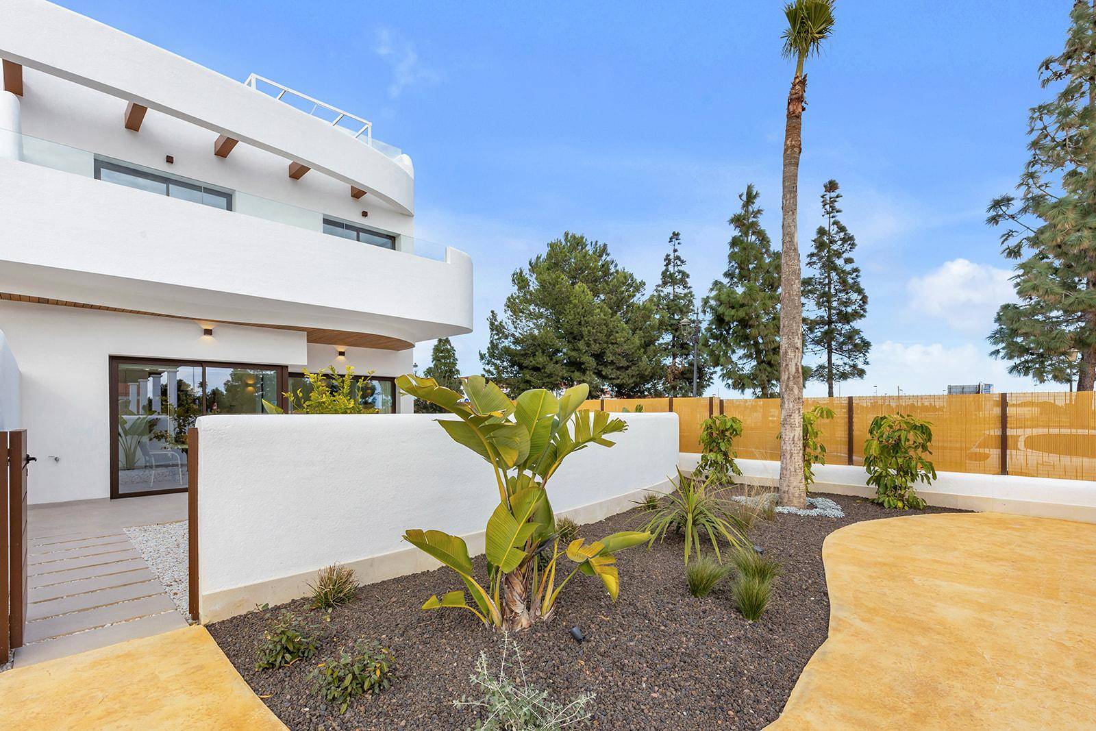 Gartenbereich mit verschiedenen Pflanzen und der modernen Architektur des Gebäudes.
