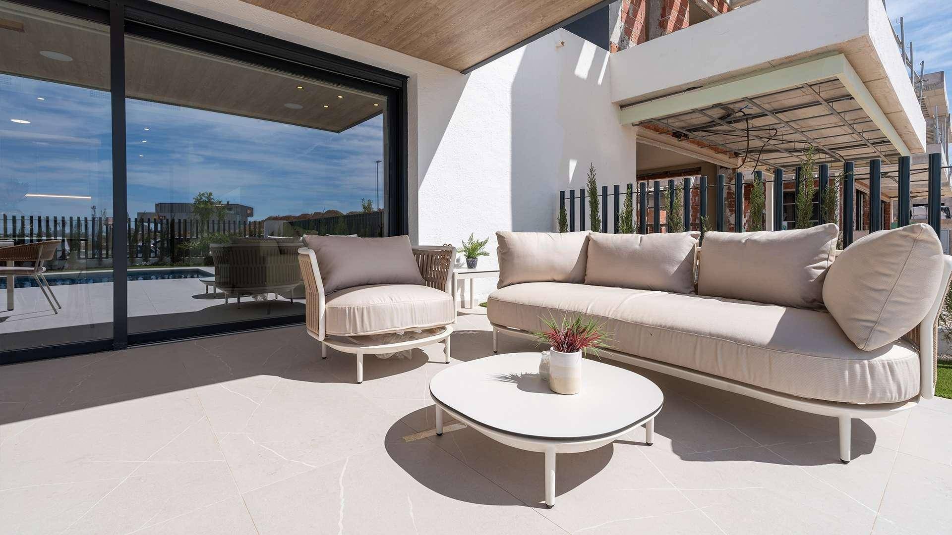 Gemütlicher Lounge-Bereich auf der Terrasse mit bequemen Sofas und einem Couchtisch unter freiem Himmel.