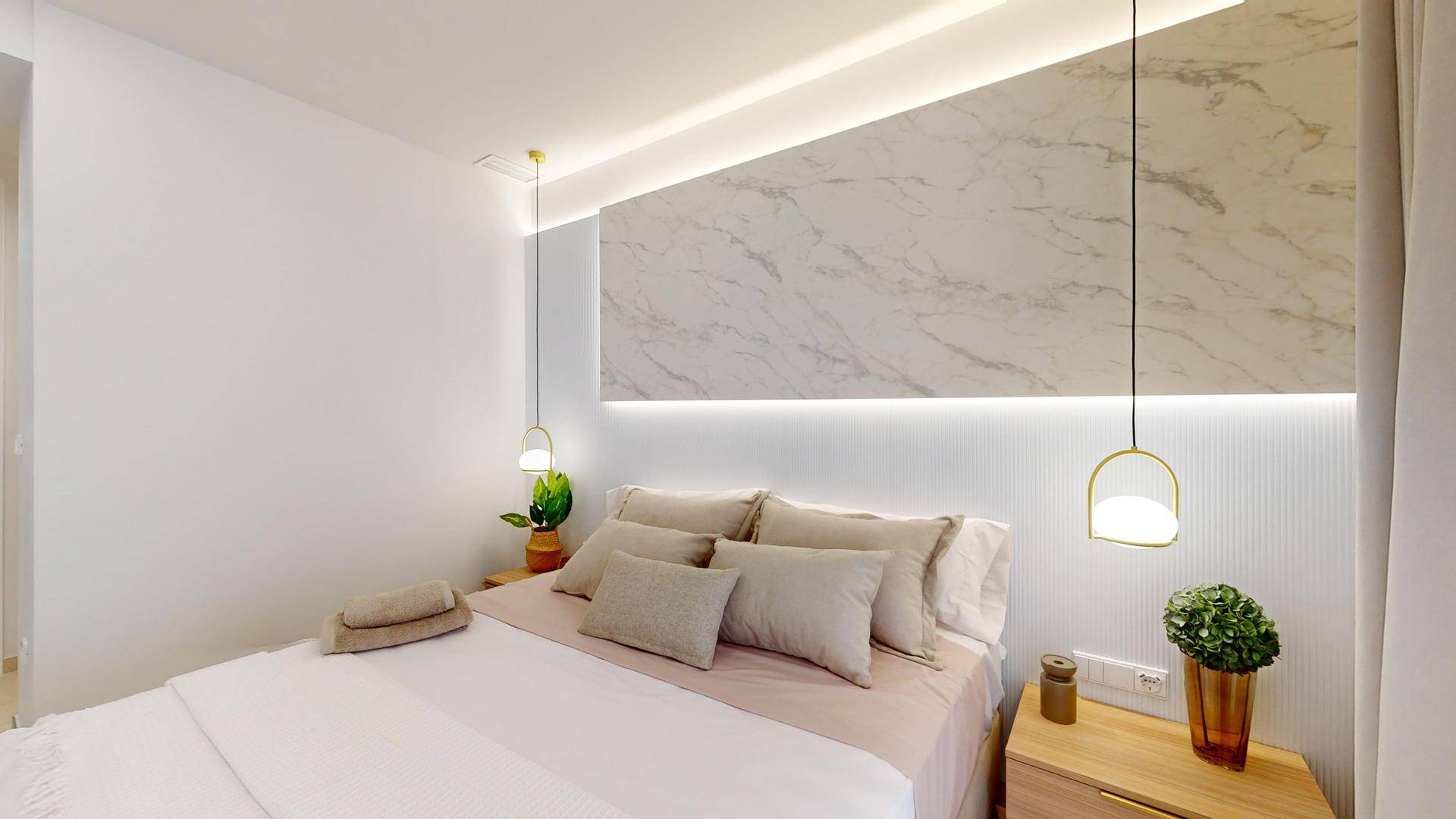 Stilvolles Schlafzimmer mit beleuchtetem Marmor-Kopfteil, minimalistischen Hängelampen und warmen Holzakzenten.