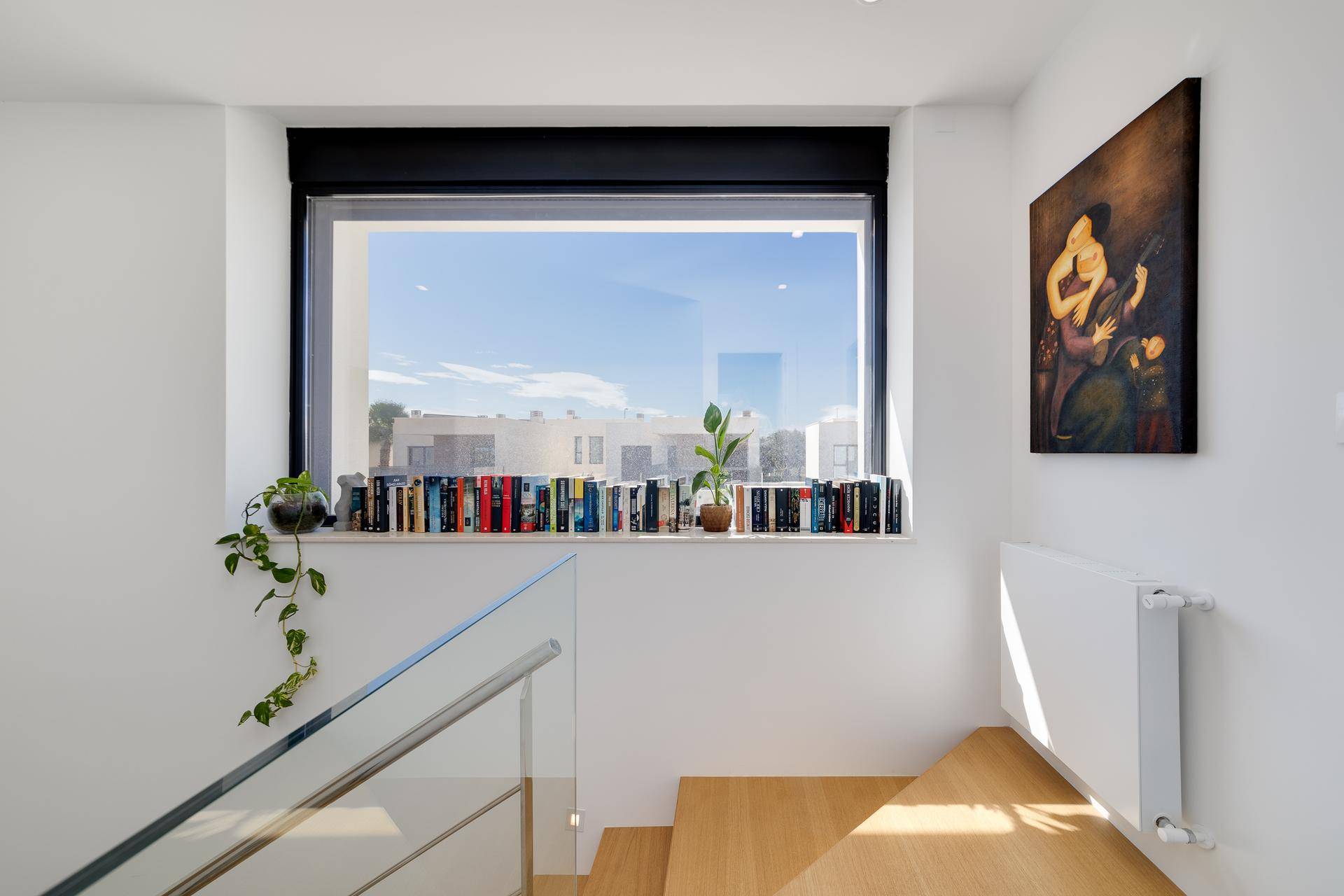 Helles Schlafzimmer mit Einbauschränken und großem Fenster mit Blick ins Grüne.