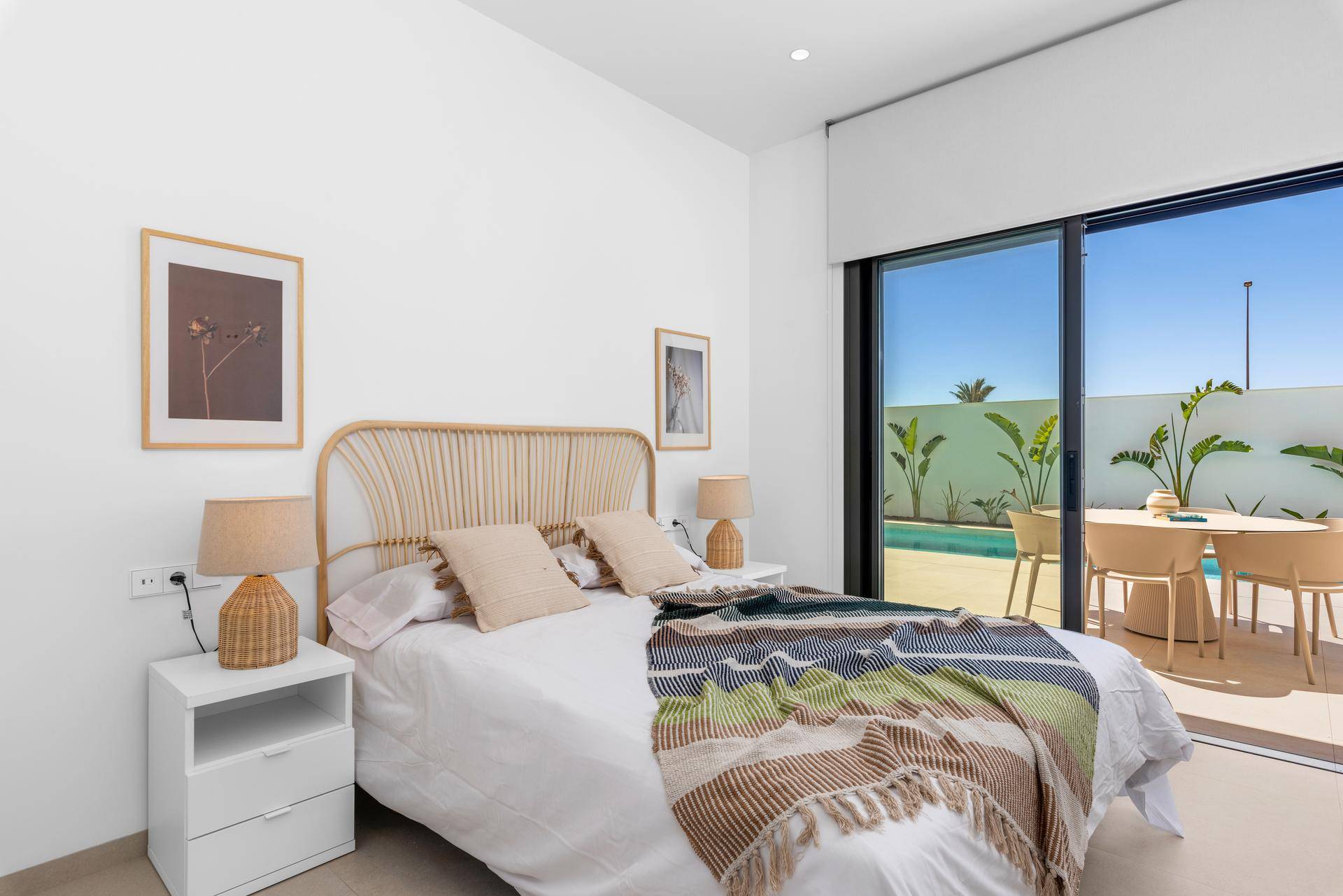 Schlafzimmer mit großem Fenster, Blick auf die Terrasse und direkten Zugang zum Außenbereich.