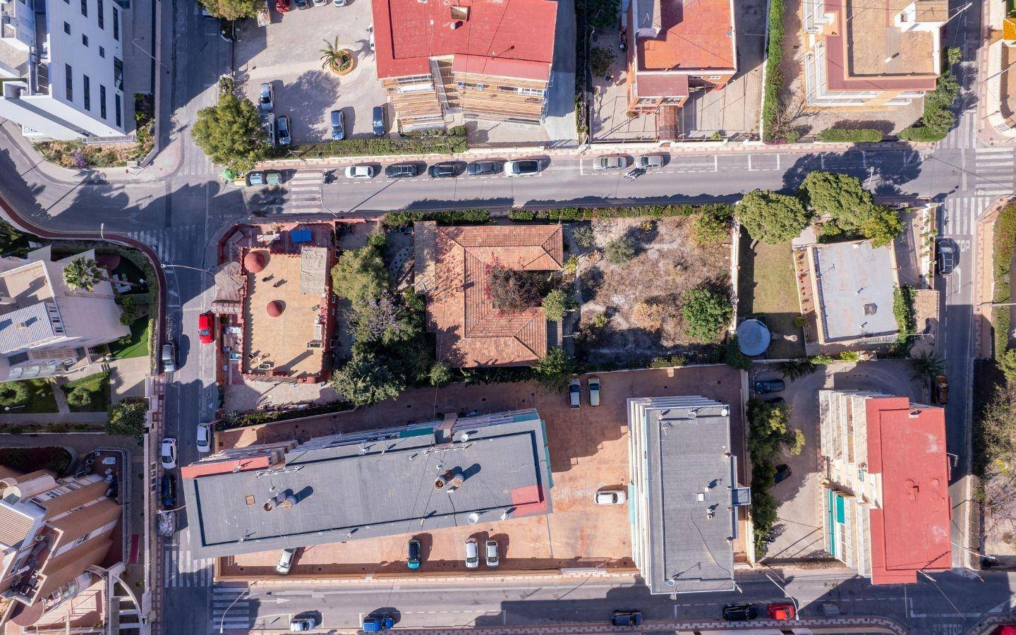 Luftaufnahme eines unbebauten Grundstücks umgeben von Gebäuden und Straßen in der Stadt.