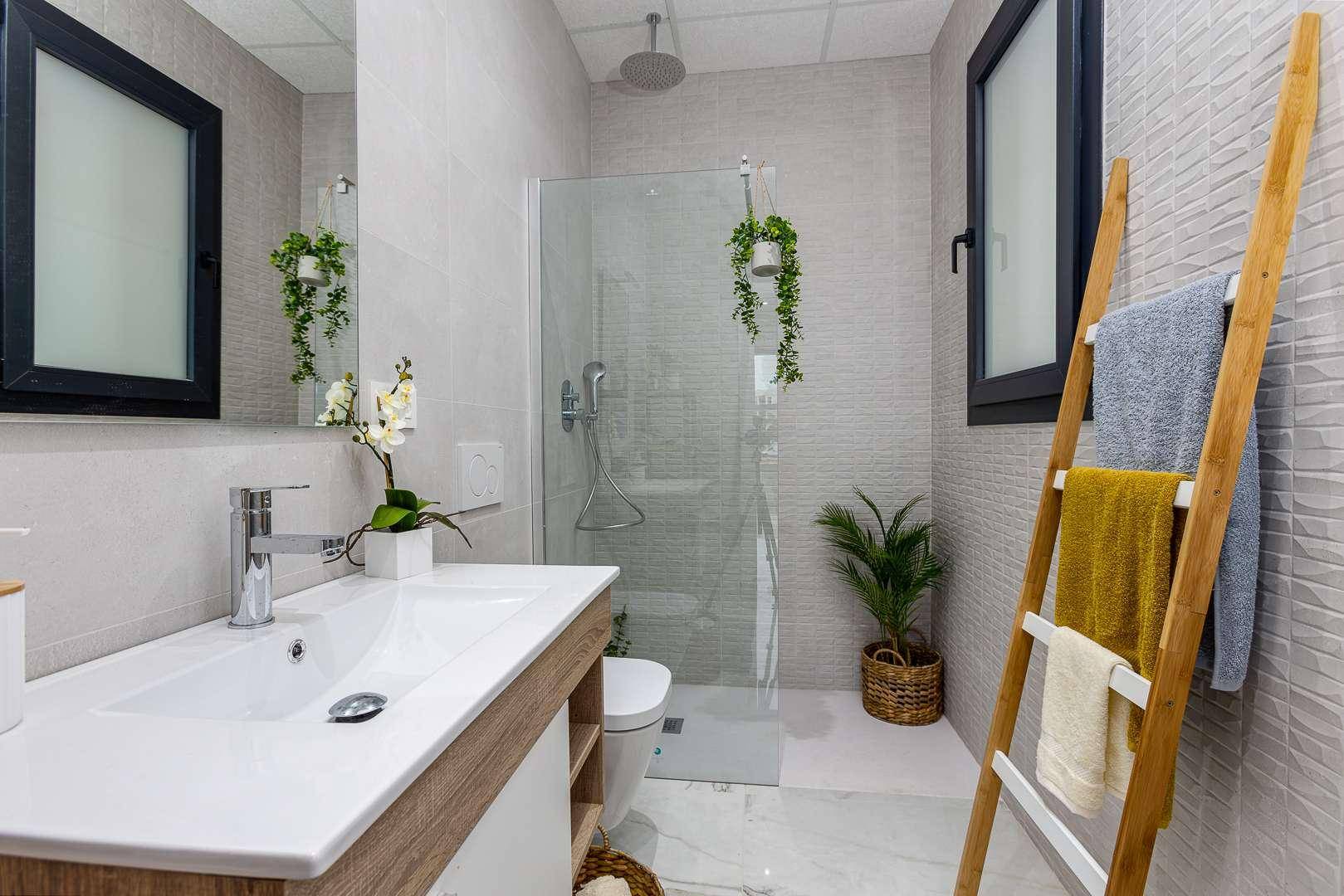 Modernes Badezimmer mit begehbarer Dusche, Fenster und stilvollen Holzdetails und Handtuchleiter.